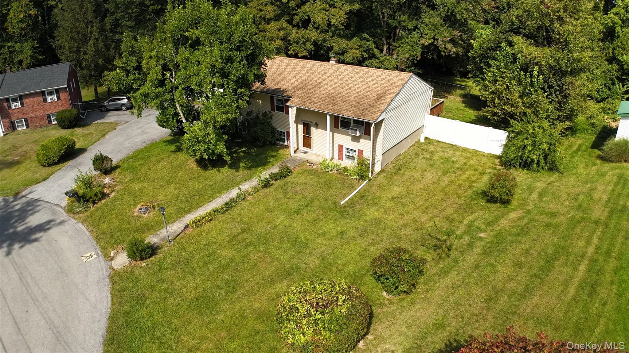 Aerial view of property and surrounding area with a forest Aerial view of property and surrounding area with a forest