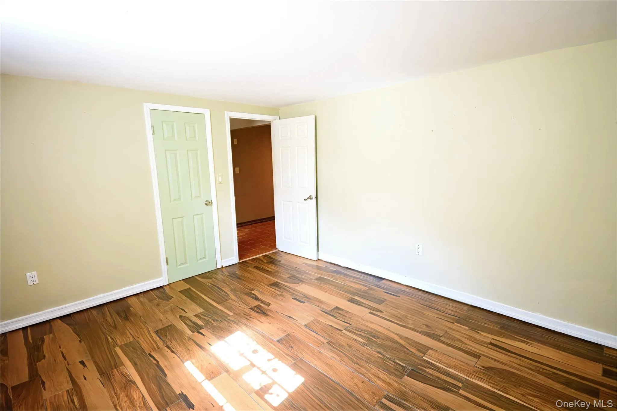 Spare room with dark wood-style floors and baseboards Spare room with dark wood-style floors and baseboards
