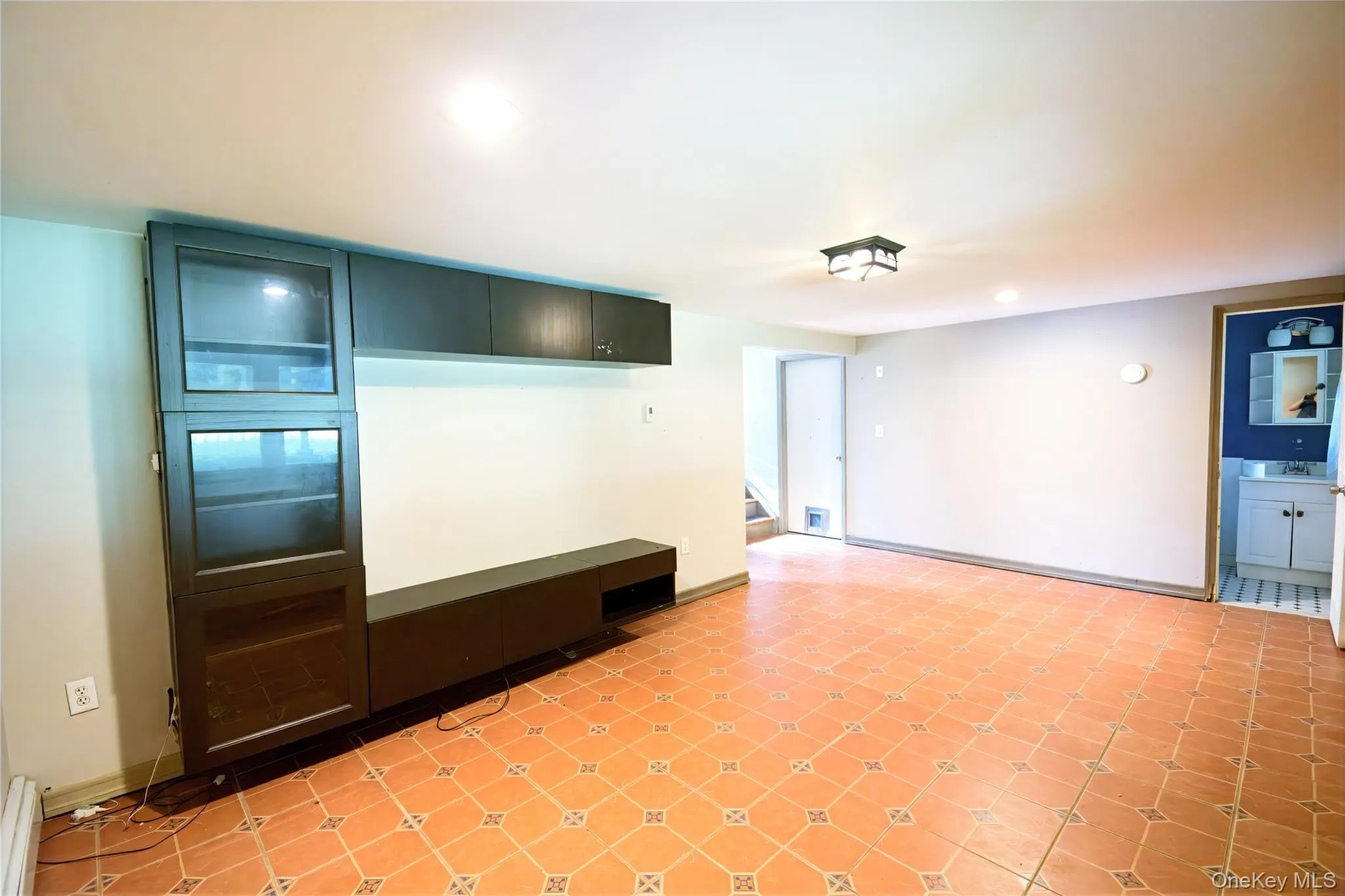 Unfurnished living room with a baseboard heating unit, recessed lighting, and light tile patterned floors Unfurnished living room with a baseboard heating unit, recessed lighting, and light tile patterned floors