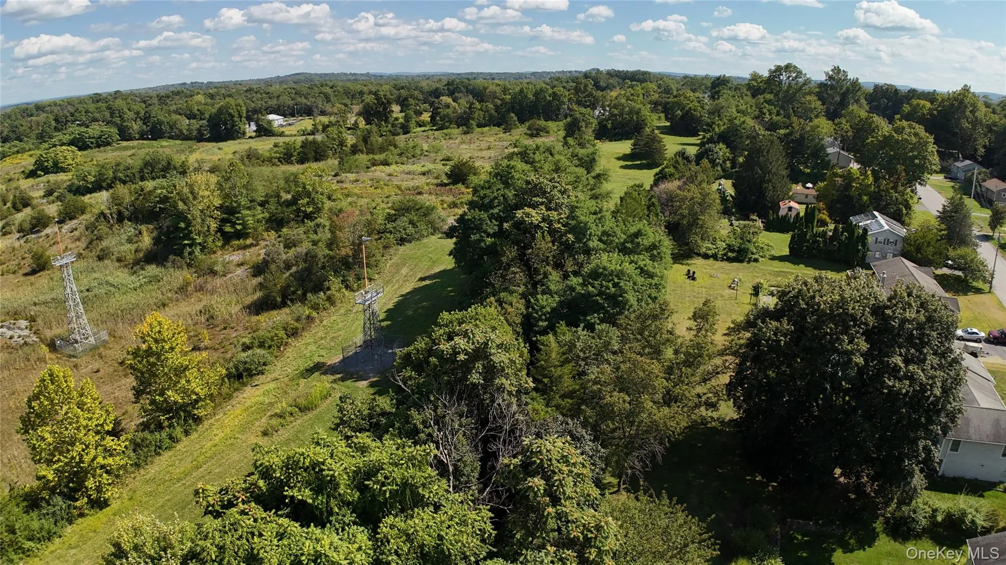 Aerial view of property and surrounding area with a heavily wooded area Aerial view of property and surrounding area with a heavily wooded area