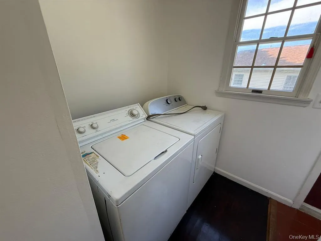 Laundry room with separate washer and dryer and dark wood-style floors Laundry room with separate washer and dryer and dark wood-style floors