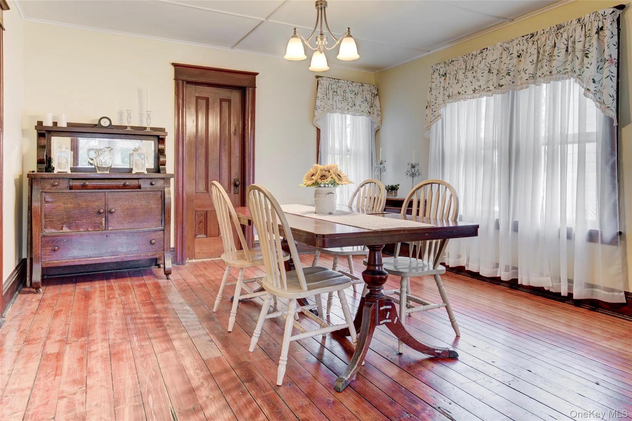 Dining area with hardwood / wood-style flooring, crown molding, and a chandelier Dining area with hardwood / wood-style flooring, crown molding, and a chandelier
