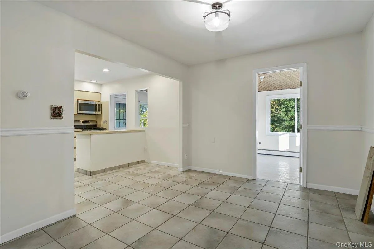 Spare room featuring light tile patterned floors and a baseboard radiator Spare room featuring light tile patterned floors and a baseboard radiator