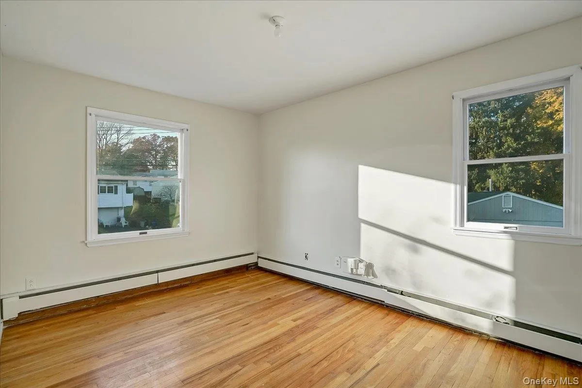 Spare room featuring a baseboard heating unit, light wood-style floors, and a baseboard radiator Spare room featuring a baseboard heating unit, light wood-style floors, and a baseboard radiator