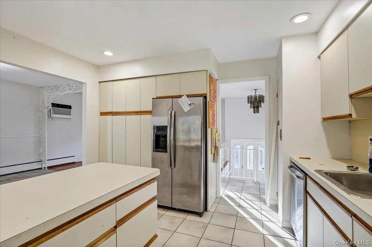 Kitchen with stainless steel appliances, light tile patterned floors, white cabinetry, and recessed lighting Kitchen with stainless steel appliances, light tile patterned floors, white cabinetry, and recessed lighting
