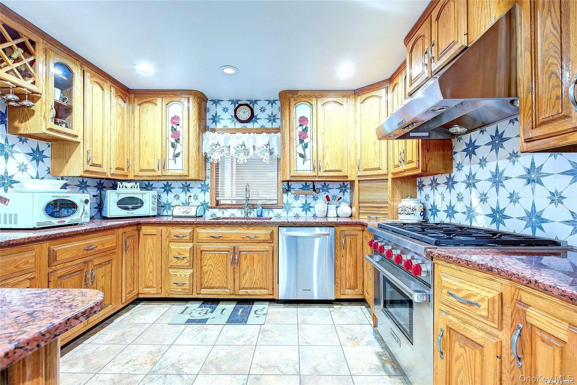 Kitchen with glass insert cabinets, stainless steel appliances, dark stone countertops, tasteful backsplash, and recessed lighting Kitchen with glass insert cabinets, stainless steel appliances, dark stone countertops, tasteful backsplash, and recessed lighting