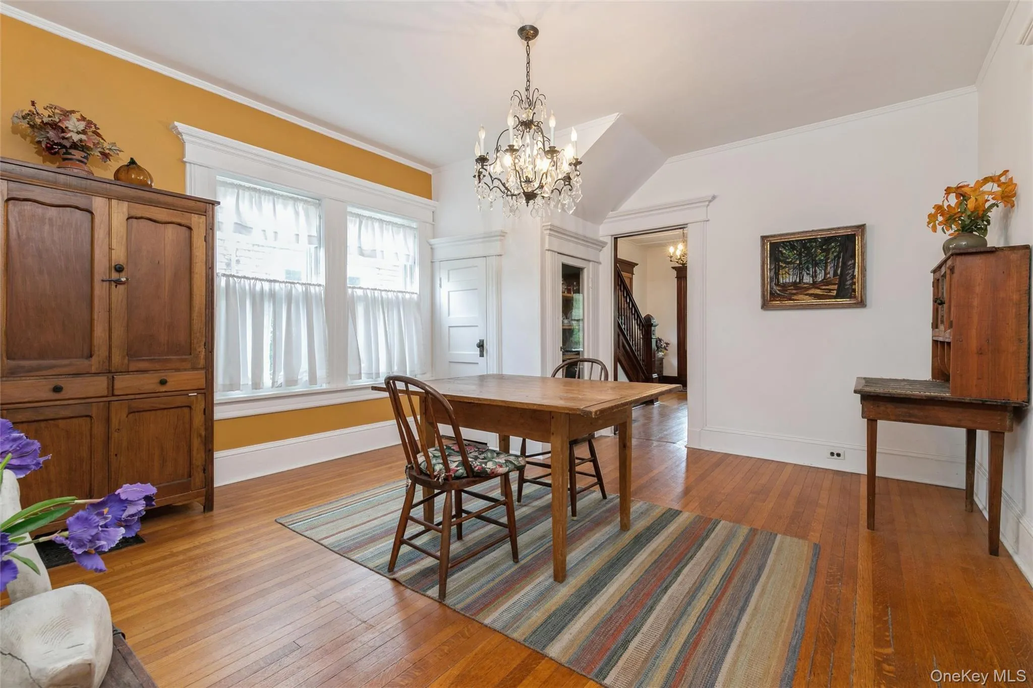 Dining room featuring crown molding, light wood-type flooring, and a chandelier Dining room featuring crown molding, light wood-type flooring, and a chandelier