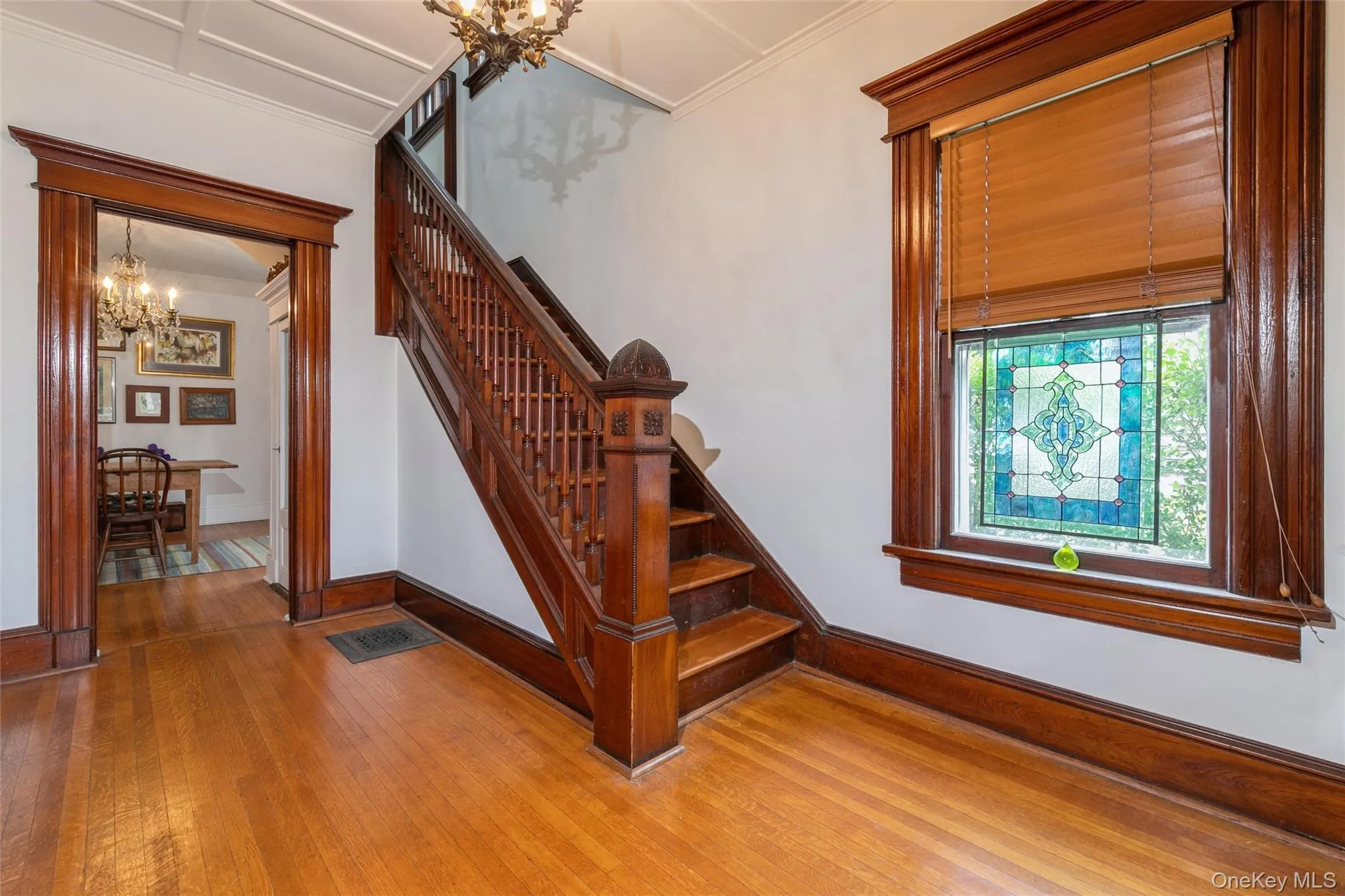Staircase featuring a chandelier, hardwood / wood-style floors, and ornamental molding Staircase featuring a chandelier, hardwood / wood-style floors, and ornamental molding