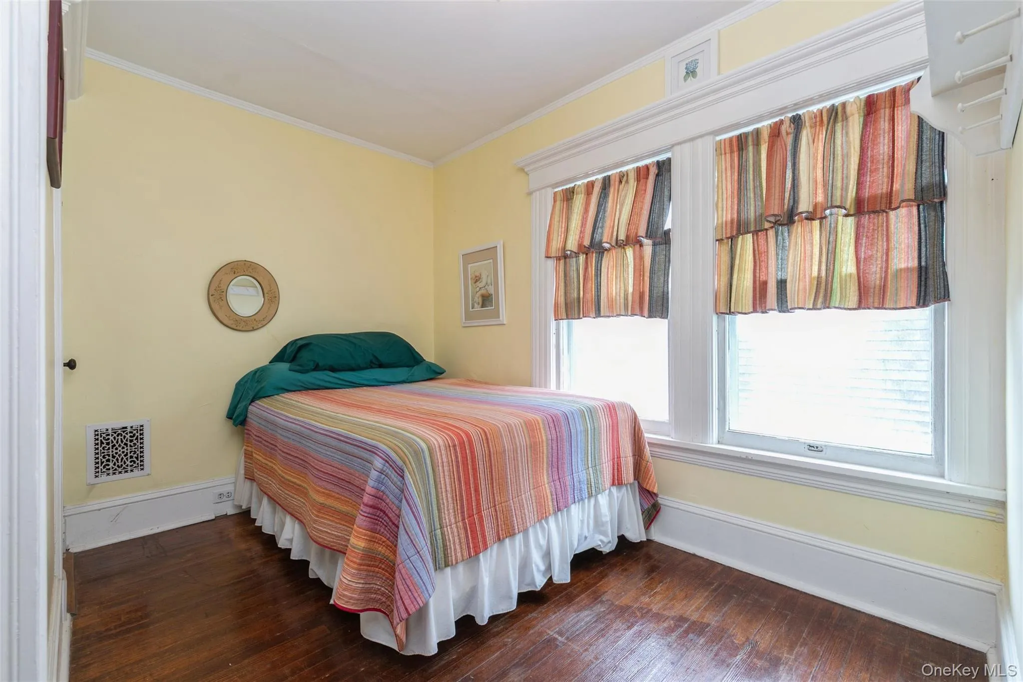 Bedroom with dark wood-style floors and ornamental molding Bedroom with dark wood-style floors and ornamental molding