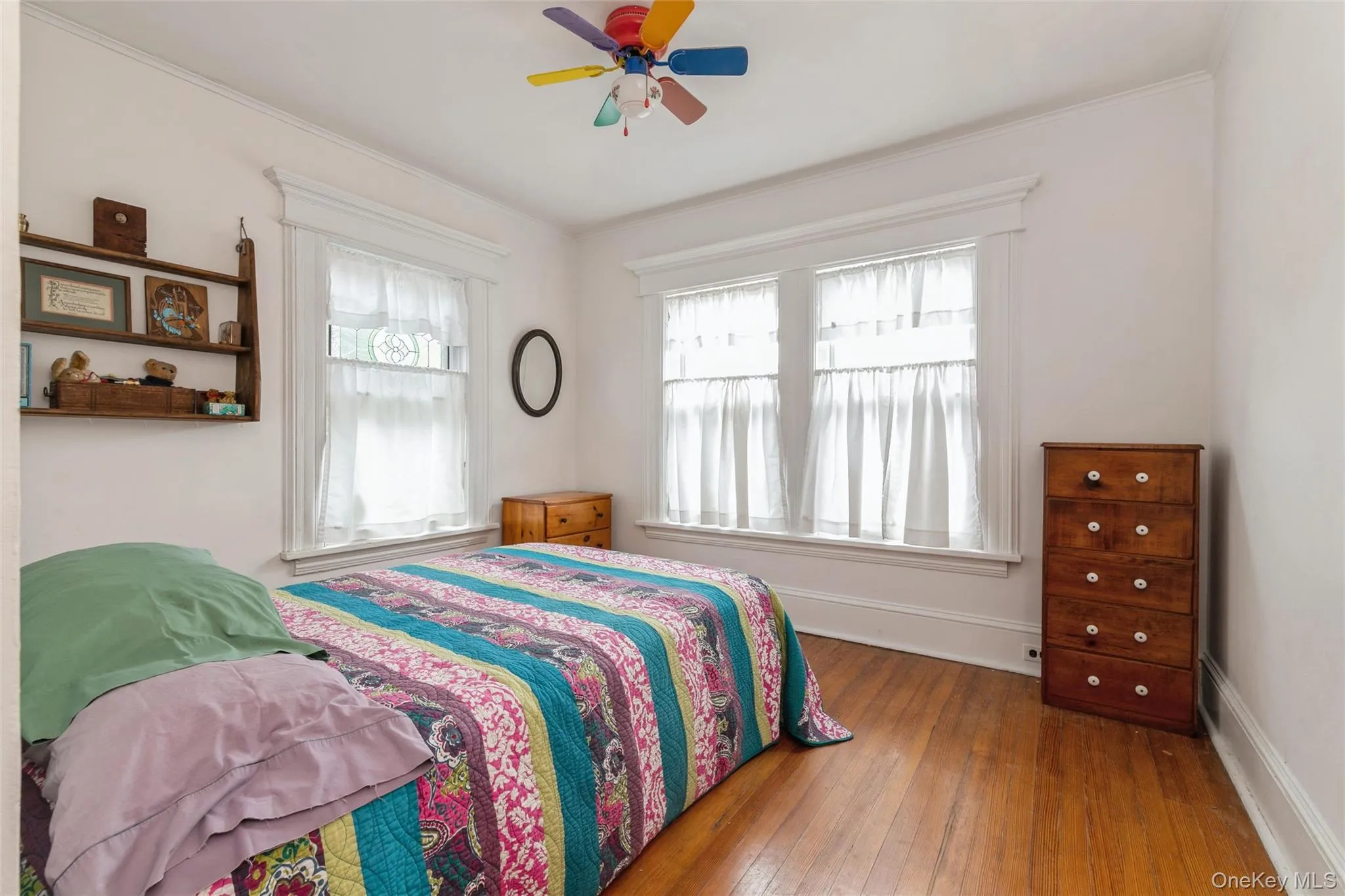 Bedroom with wood-type flooring, a ceiling fan, and crown molding Bedroom with wood-type flooring, a ceiling fan, and crown molding