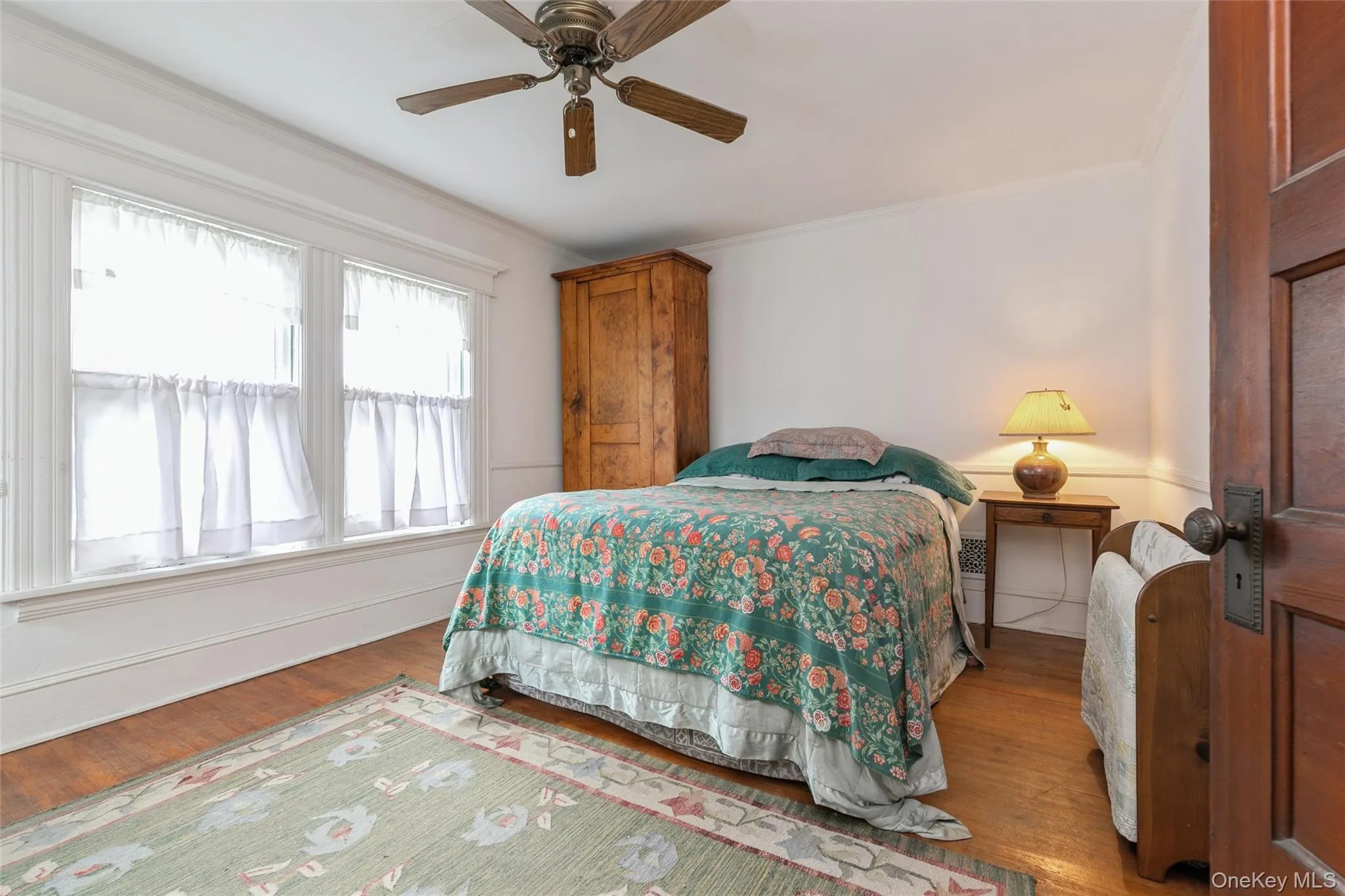 Bedroom featuring ornamental molding, wood finished floors, and ceiling fan Bedroom featuring ornamental molding, wood finished floors, and ceiling fan