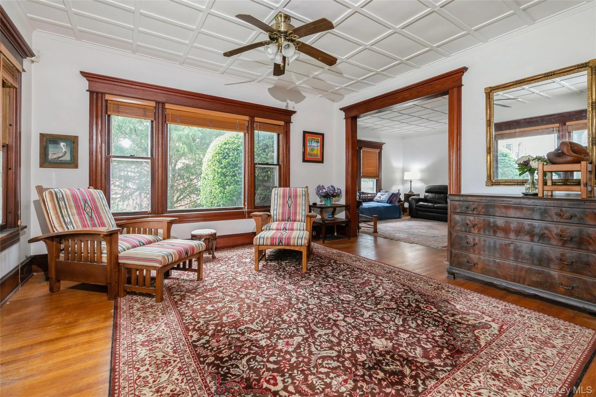 Sitting room featuring healthy amount of natural light, wood finished floors, and a ceiling fan Sitting room featuring healthy amount of natural light, wood finished floors, and a ceiling fan