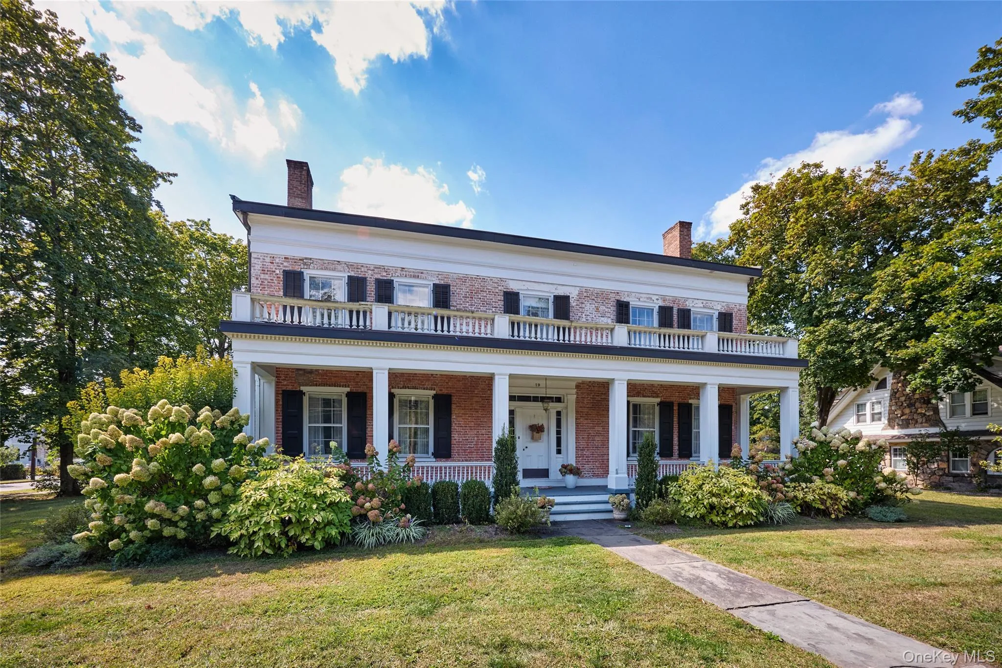 View of front of home with a chimney, brick siding, a front yard, and a porch View of front of home with a chimney, brick siding, a front yard, and a porch