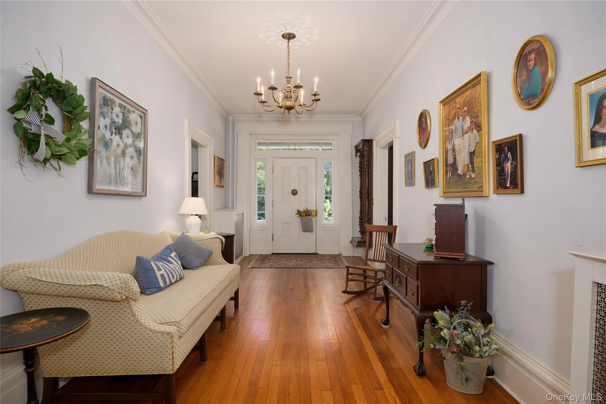 Foyer featuring wood-type flooring, a chandelier, and crown molding Foyer featuring wood-type flooring, a chandelier, and crown molding