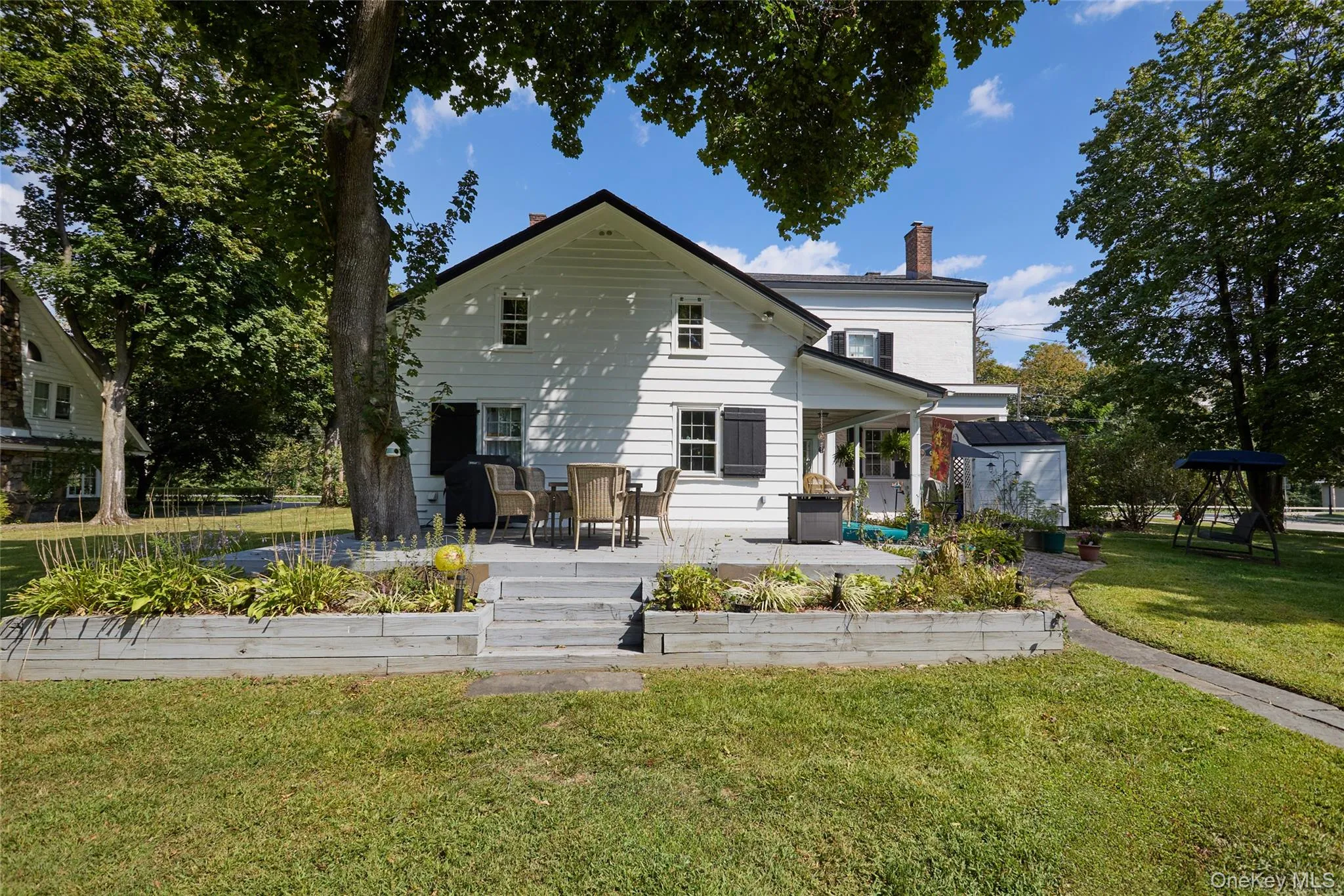 Back of house with a patio, a lawn, and a chimney Back of house with a patio, a lawn, and a chimney