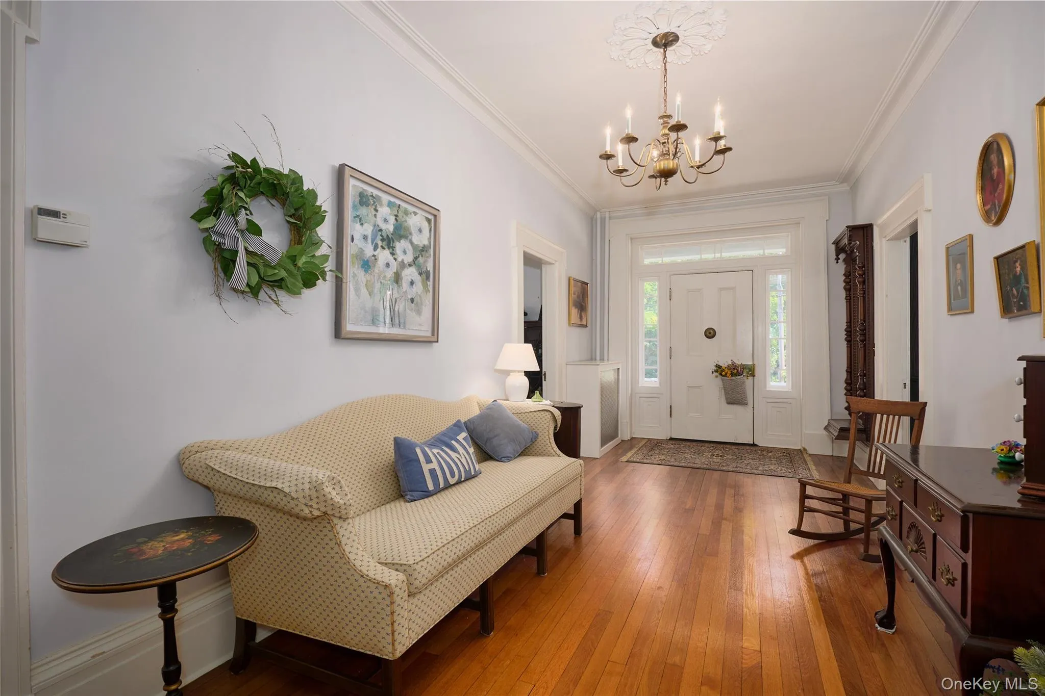Entryway with hardwood / wood-style floors, crown molding, and a chandelier Entryway with hardwood / wood-style floors, crown molding, and a chandelier
