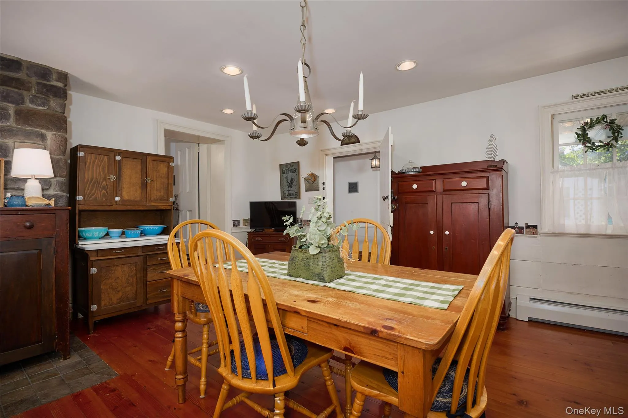 Dining area with dark wood finished floors, a chandelier, recessed lighting, and a baseboard radiator Dining area with dark wood finished floors, a chandelier, recessed lighting, and a baseboard radiator