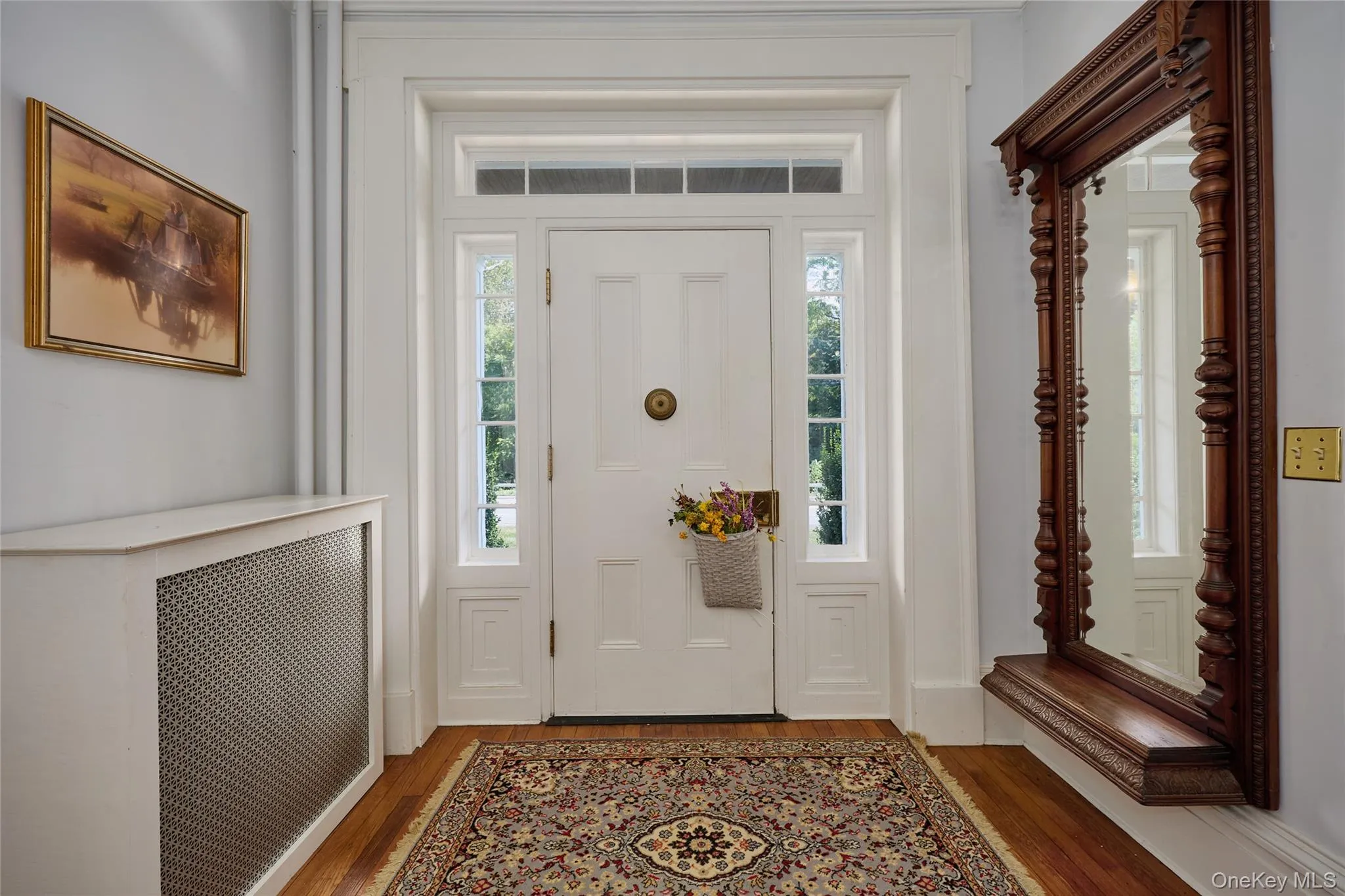 Foyer entrance with radiator heating unit and wood finished floors Foyer entrance with radiator heating unit and wood finished floors