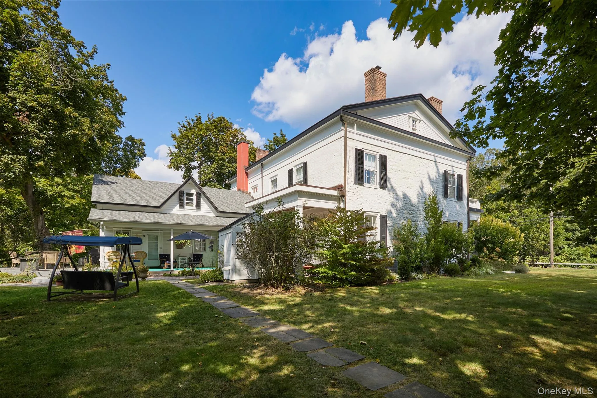 View of side of property featuring a chimney, a porch, and a lawn View of side of property featuring a chimney, a porch, and a lawn