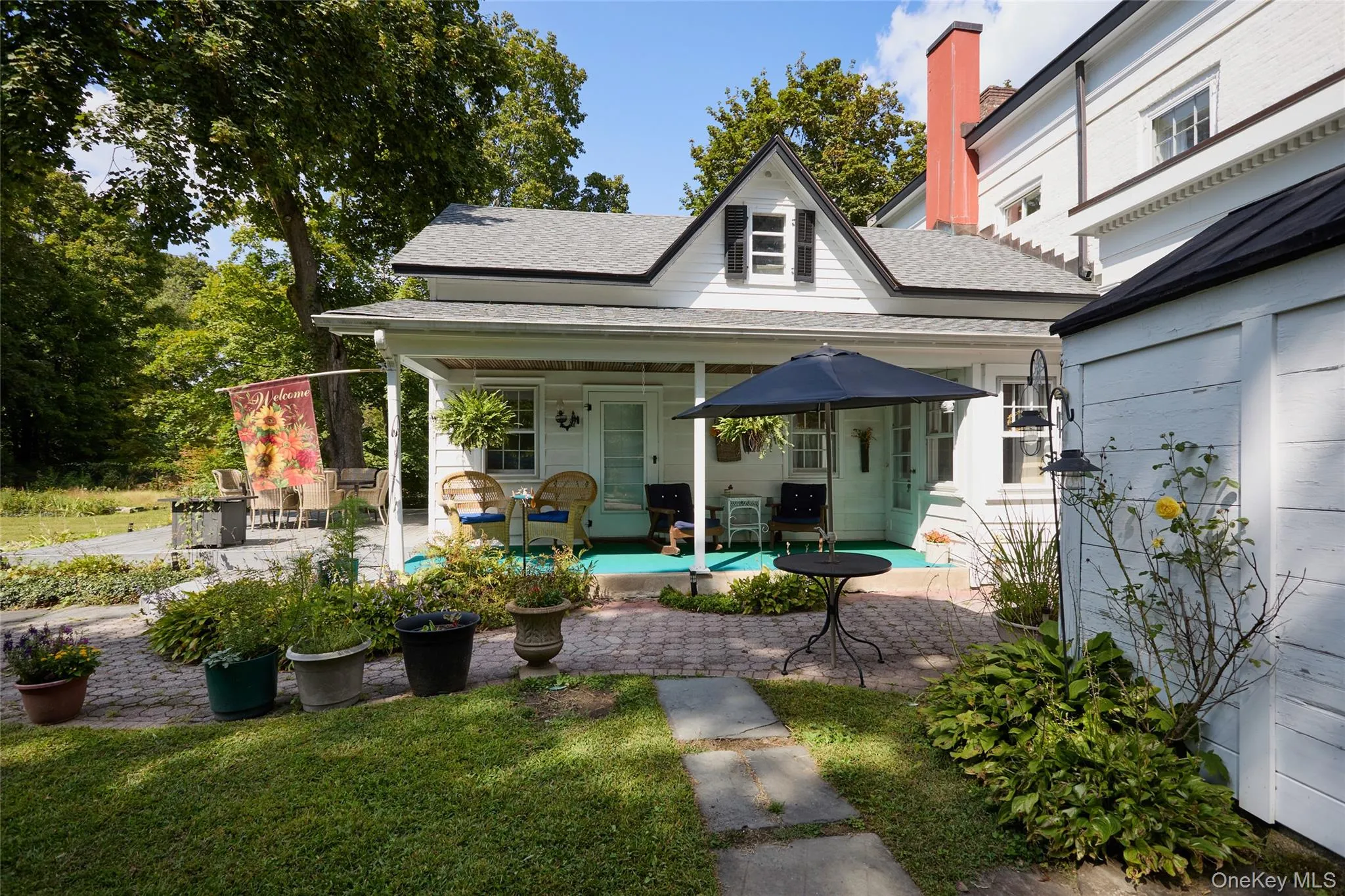 Rear view of property featuring a shingled roof, a patio area, and a lawn Rear view of property featuring a shingled roof, a patio area, and a lawn