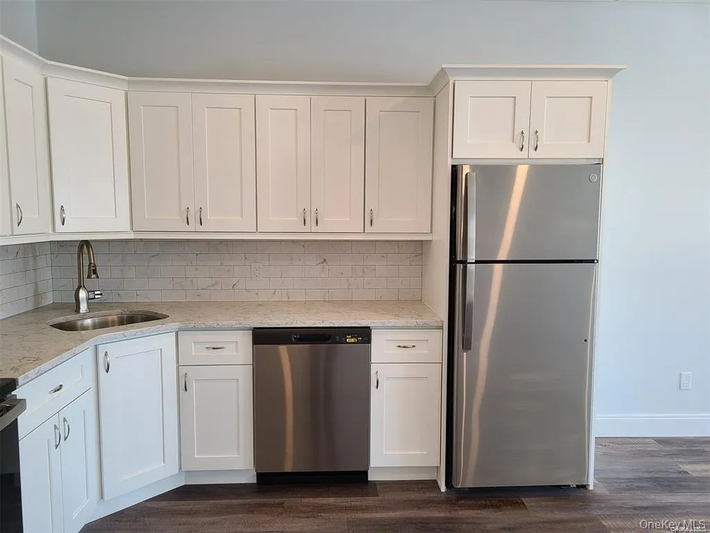 Kitchen with appliances with stainless steel finishes, white cabinets, and tasteful backsplash Kitchen with appliances with stainless steel finishes, white cabinets, and tasteful backsplash