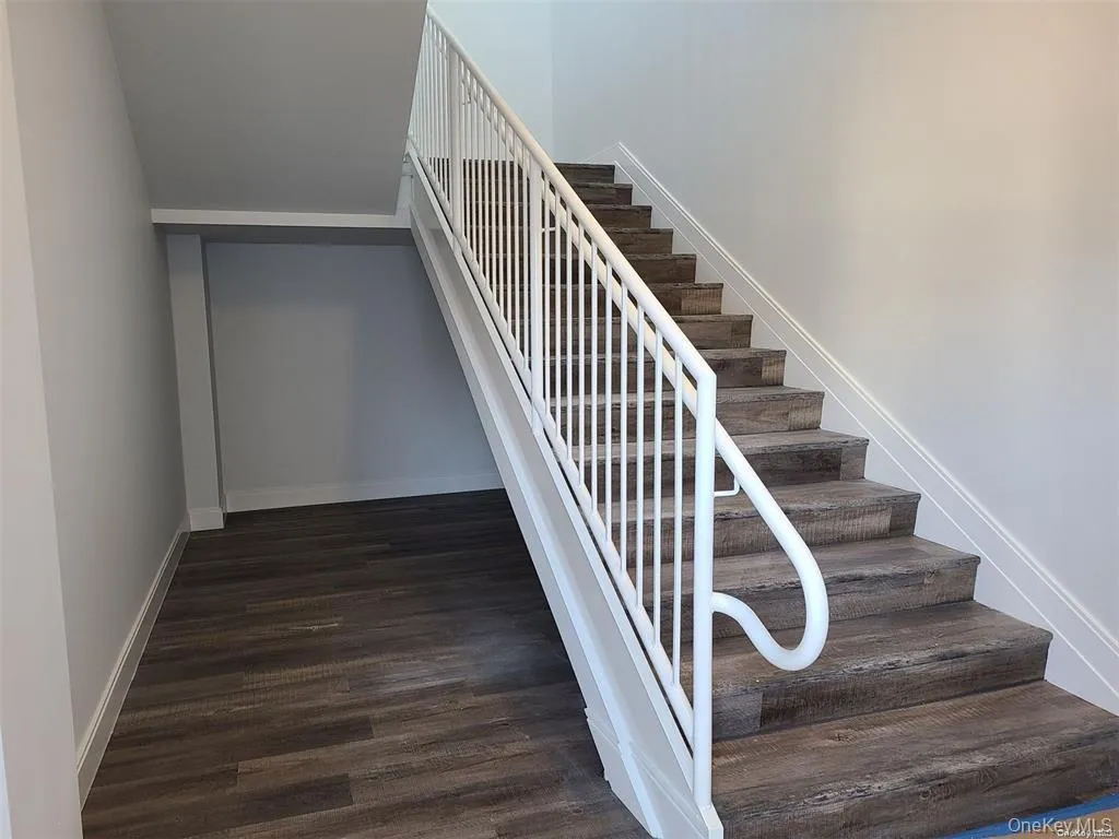 Staircase with baseboards and wood finished floors Staircase with baseboards and wood finished floors