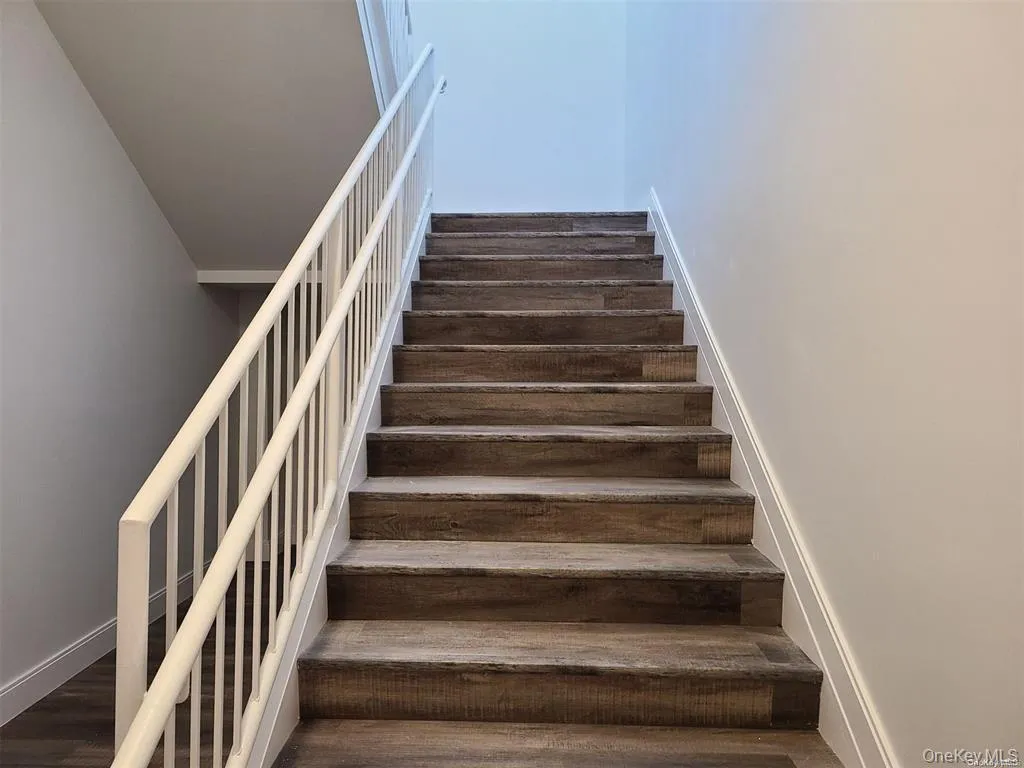 Stairway featuring baseboards and wood finished floors Stairway featuring baseboards and wood finished floors