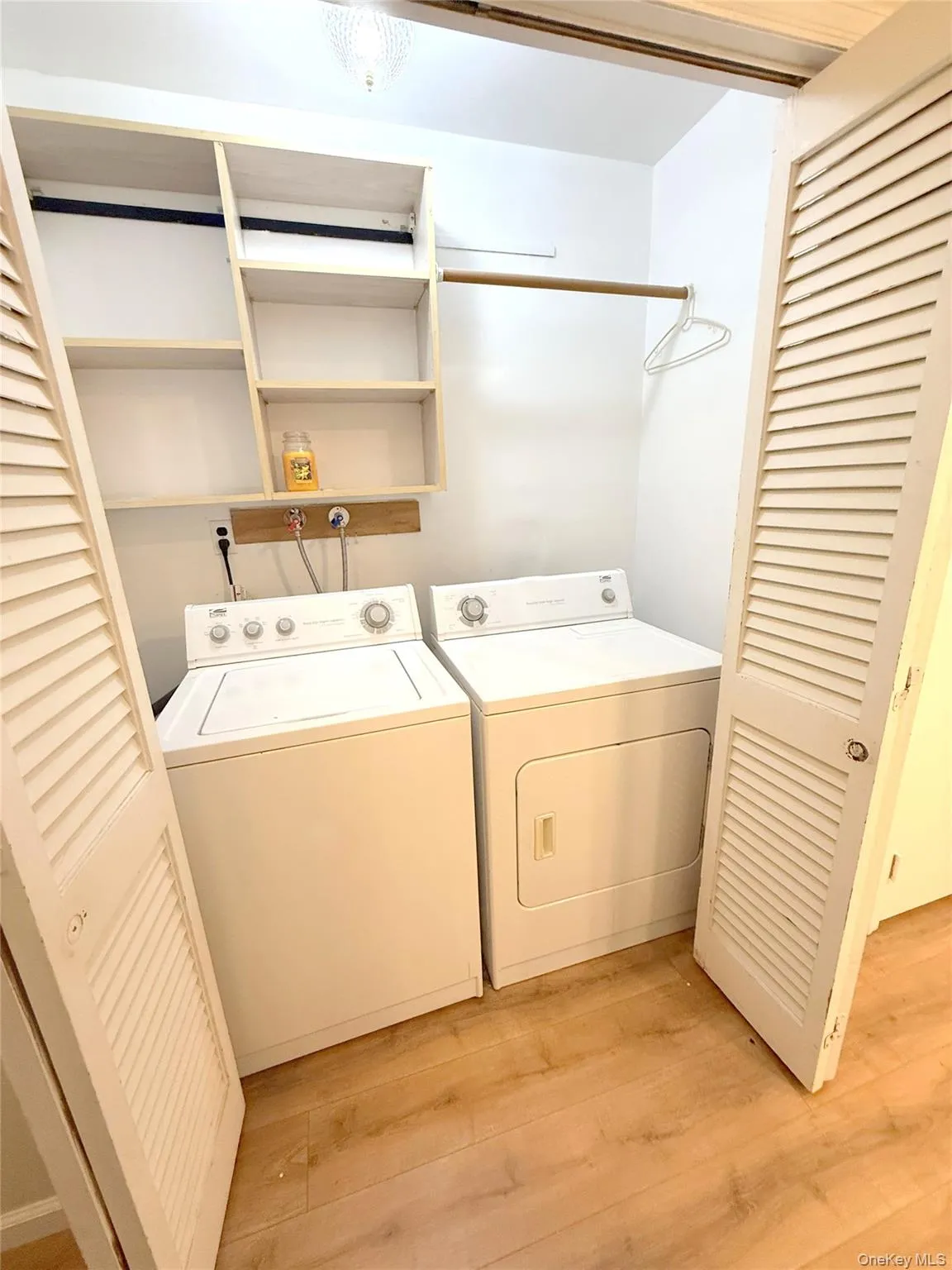 Laundry area featuring light wood finished floors and washing machine and clothes dryer Laundry area featuring light wood finished floors and washing machine and clothes dryer
