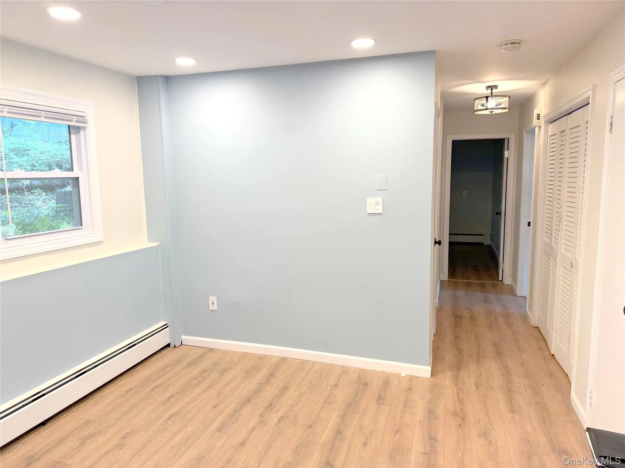 Unfurnished room featuring a baseboard heating unit, light wood-type flooring, and recessed lighting Unfurnished room featuring a baseboard heating unit, light wood-type flooring, and recessed lighting