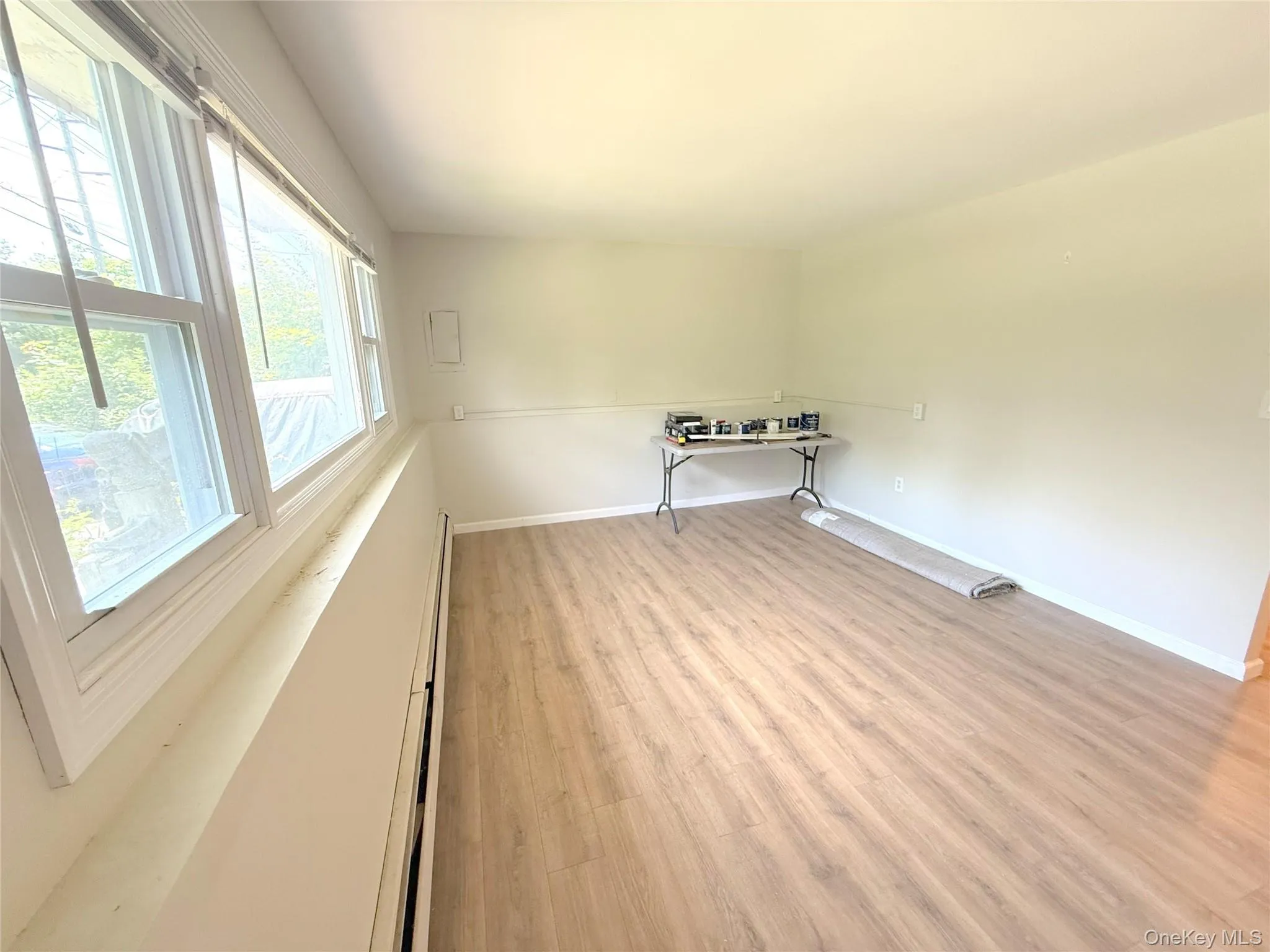 Spare room with light wood-type flooring and a baseboard heating unit Spare room with light wood-type flooring and a baseboard heating unit