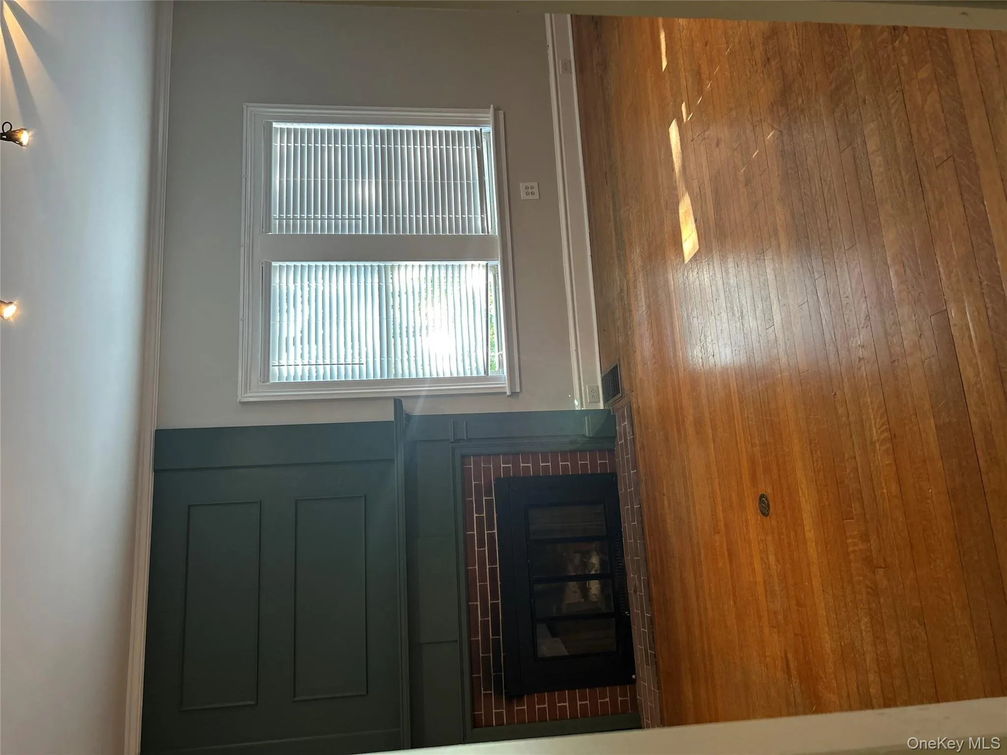 Unfurnished living room with a large fireplace, crown molding, and hardwood / wood-style flooring Unfurnished living room with a large fireplace, crown molding, and hardwood / wood-style flooring