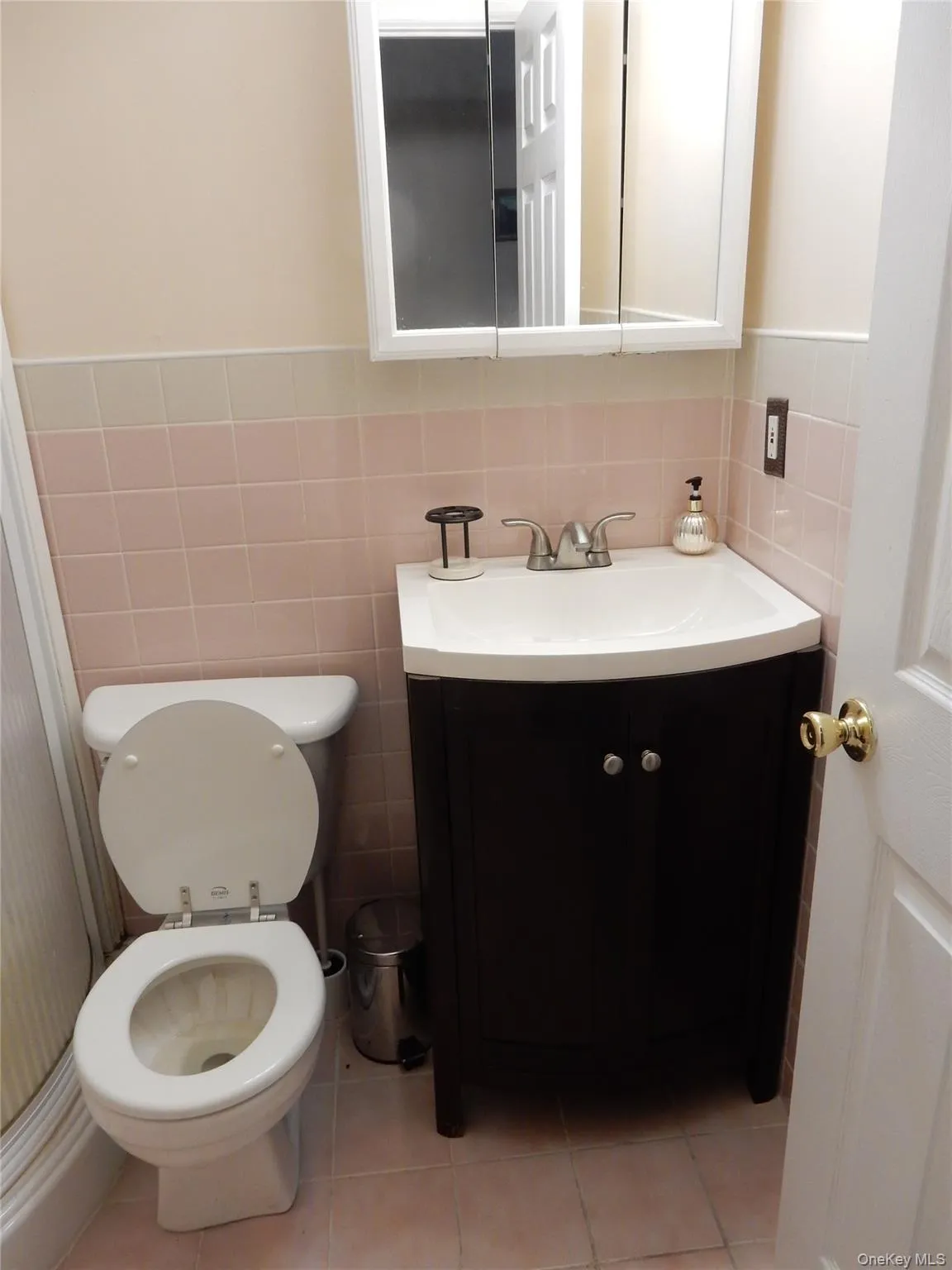 Bathroom featuring vanity, tile walls, and light tile patterned floors Bathroom featuring vanity, tile walls, and light tile patterned floors