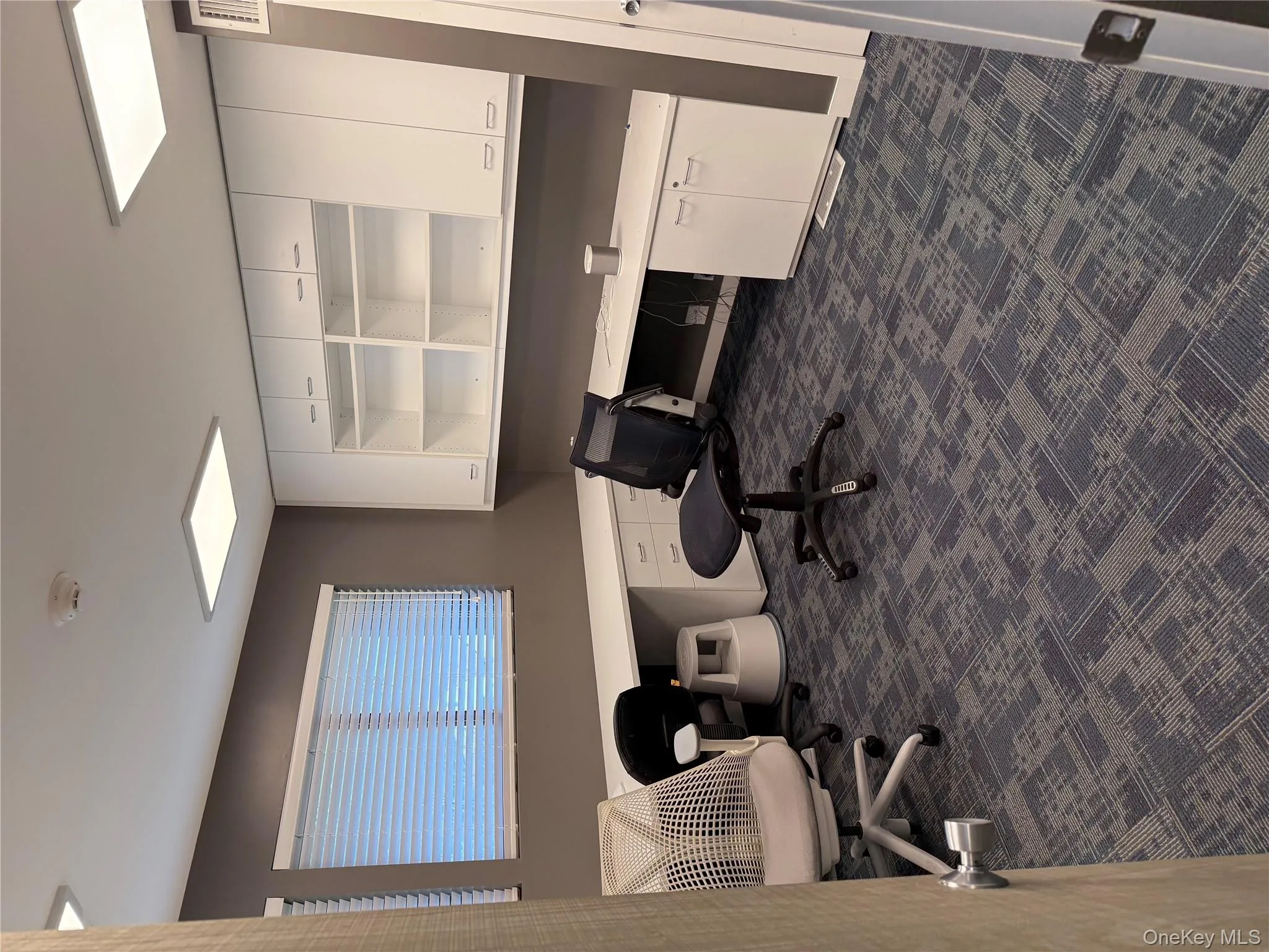 Office with dark carpet and built in study area Office with dark carpet and built in study area