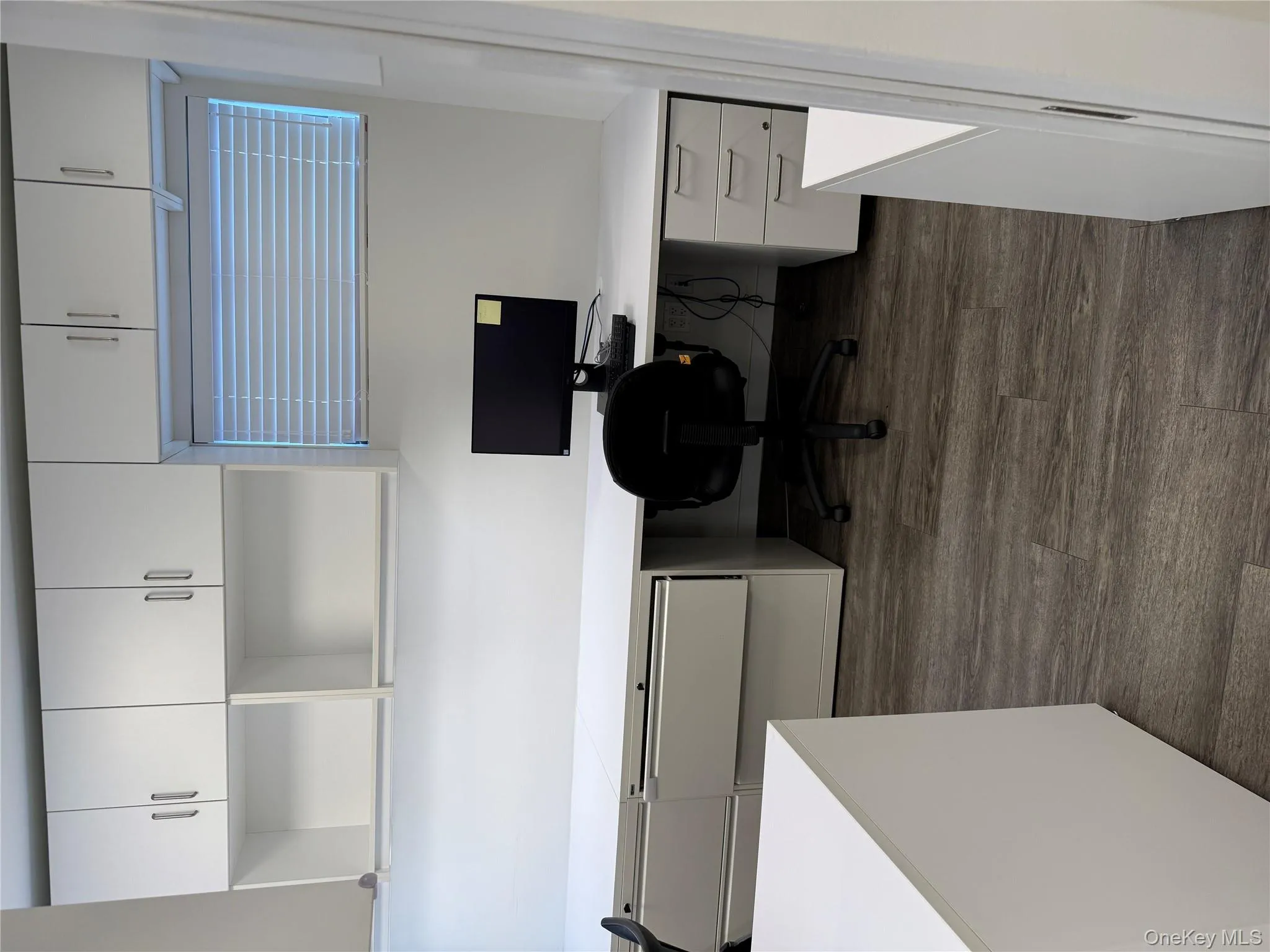 Office space with built in study area and dark wood-type flooring Office space with built in study area and dark wood-type flooring