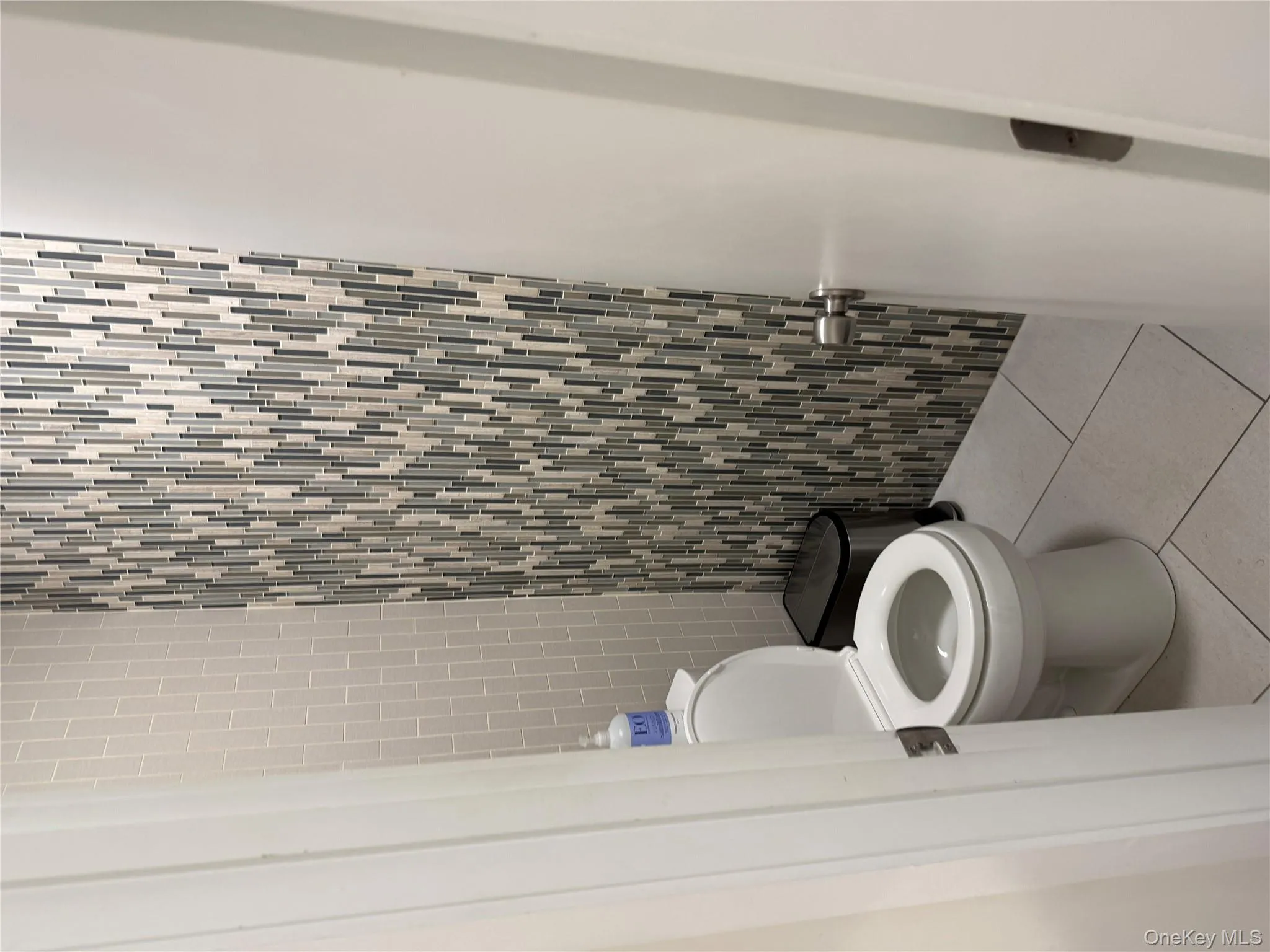 Bathroom with tile patterned flooring and tile walls Bathroom with tile patterned flooring and tile walls