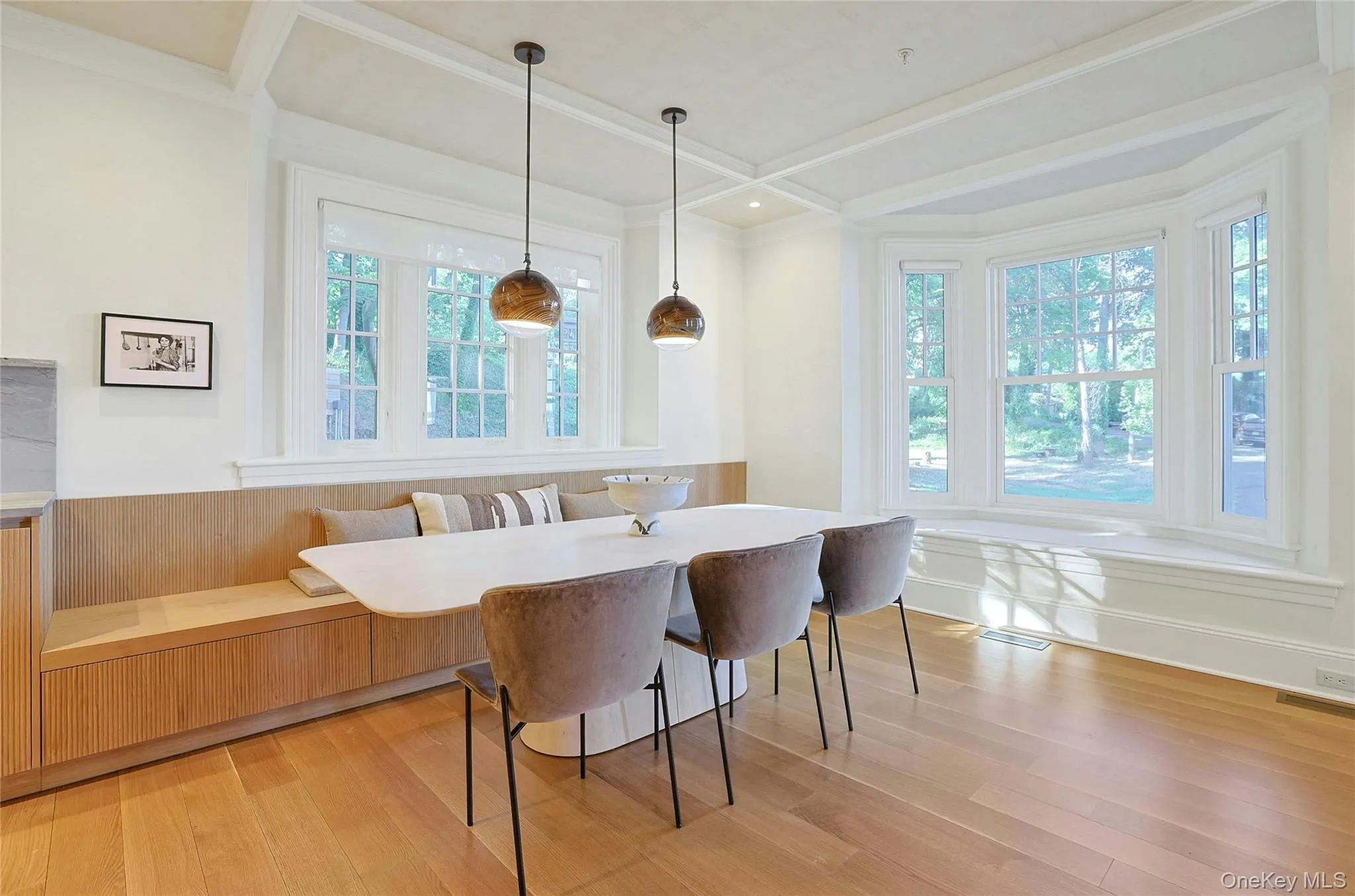 Dining space with breakfast area, light wood finished floors, beam ceiling, a wainscoted wall, and crown molding Dining space with breakfast area, light wood finished floors, beam ceiling, a wainscoted wall, and crown molding