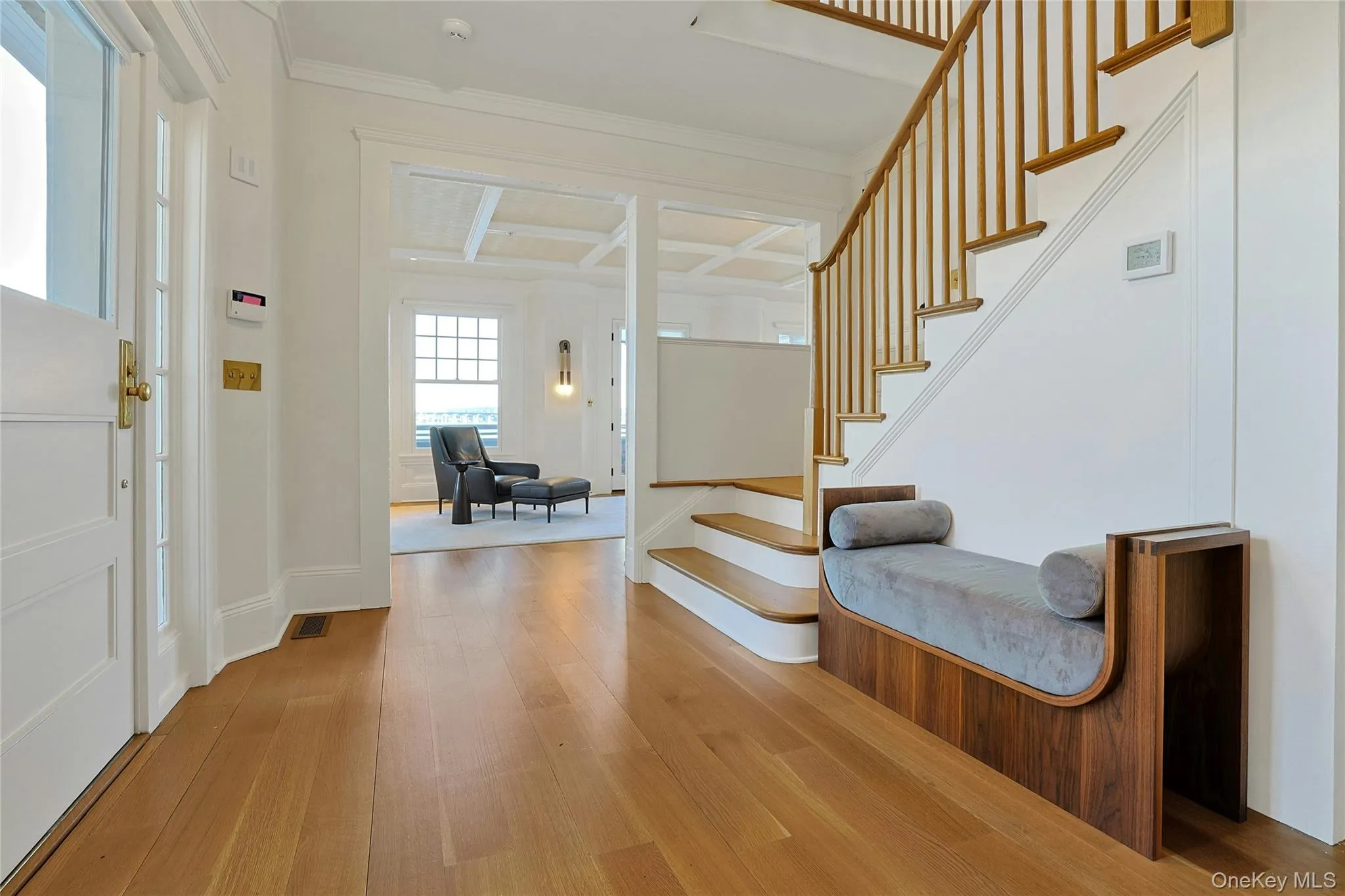 Entrance foyer featuring light wood-style flooring, crown molding, and stairs Entrance foyer featuring light wood-style flooring, crown molding, and stairs