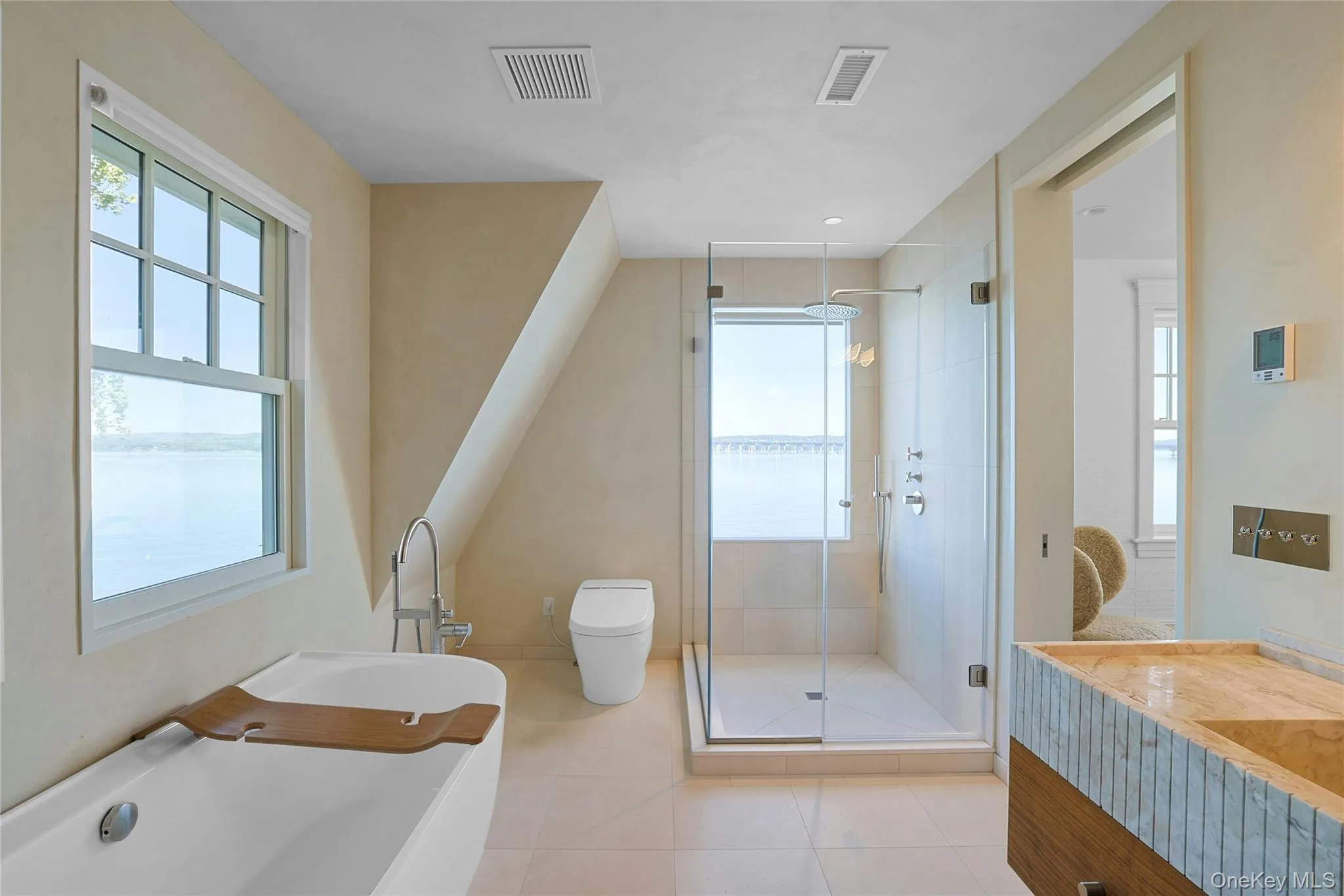 Full bathroom with a shower stall, a freestanding bath, light tile patterned flooring, and vanity Full bathroom with a shower stall, a freestanding bath, light tile patterned flooring, and vanity