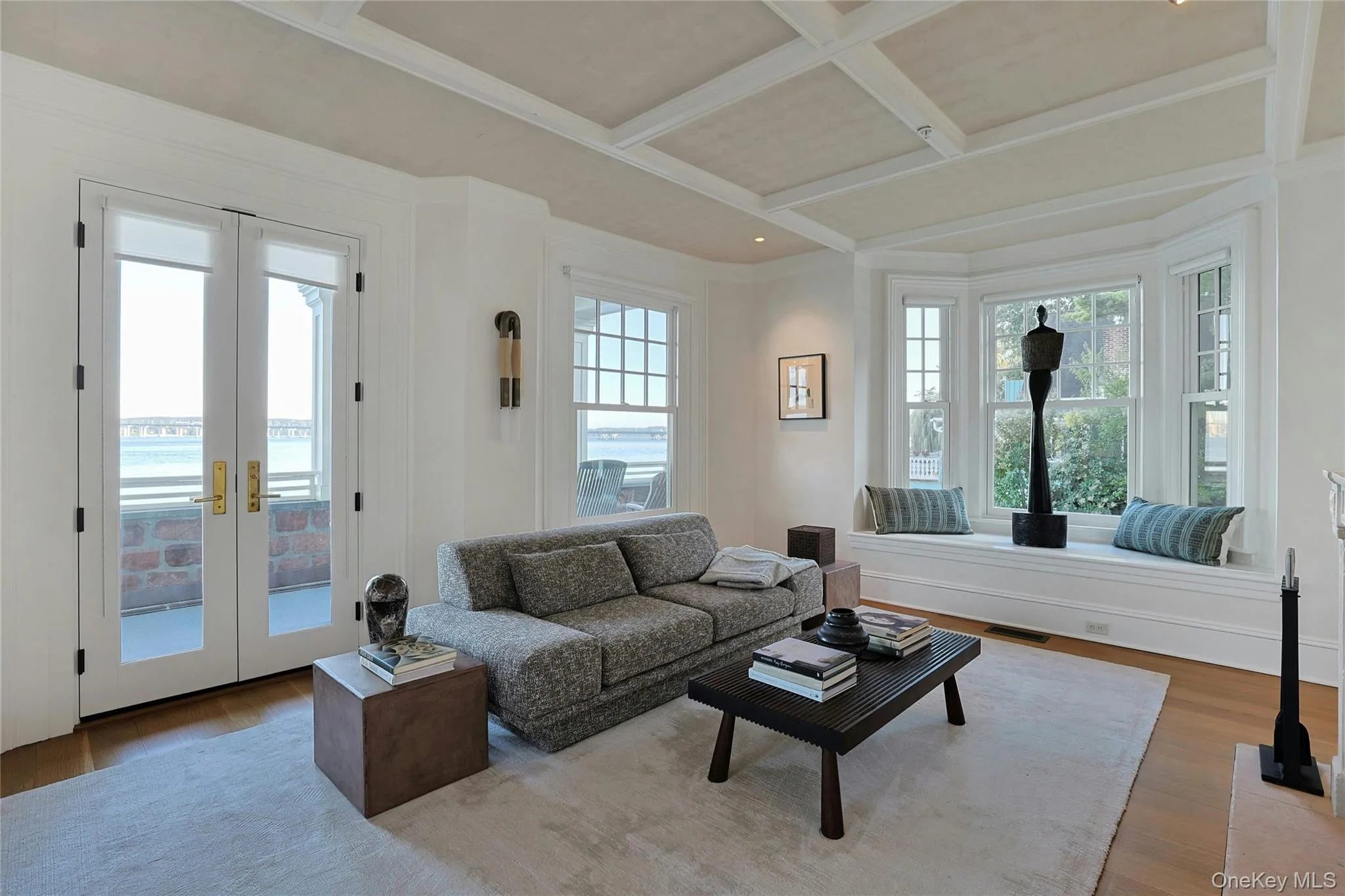 Living room featuring french doors, wood finished floors, coffered ceiling, beam ceiling, and crown molding Living room featuring french doors, wood finished floors, coffered ceiling, beam ceiling, and crown molding