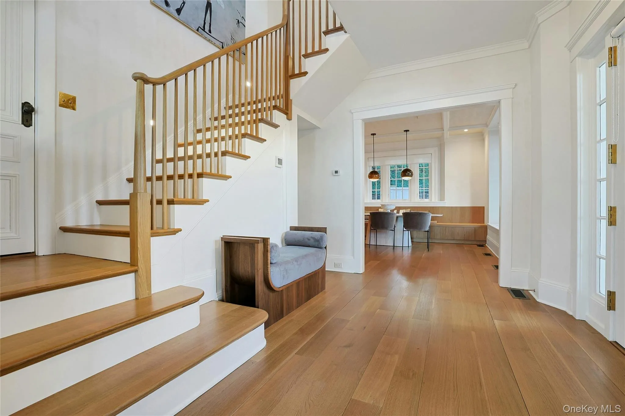 Staircase featuring wood finished floors and crown molding Staircase featuring wood finished floors and crown molding