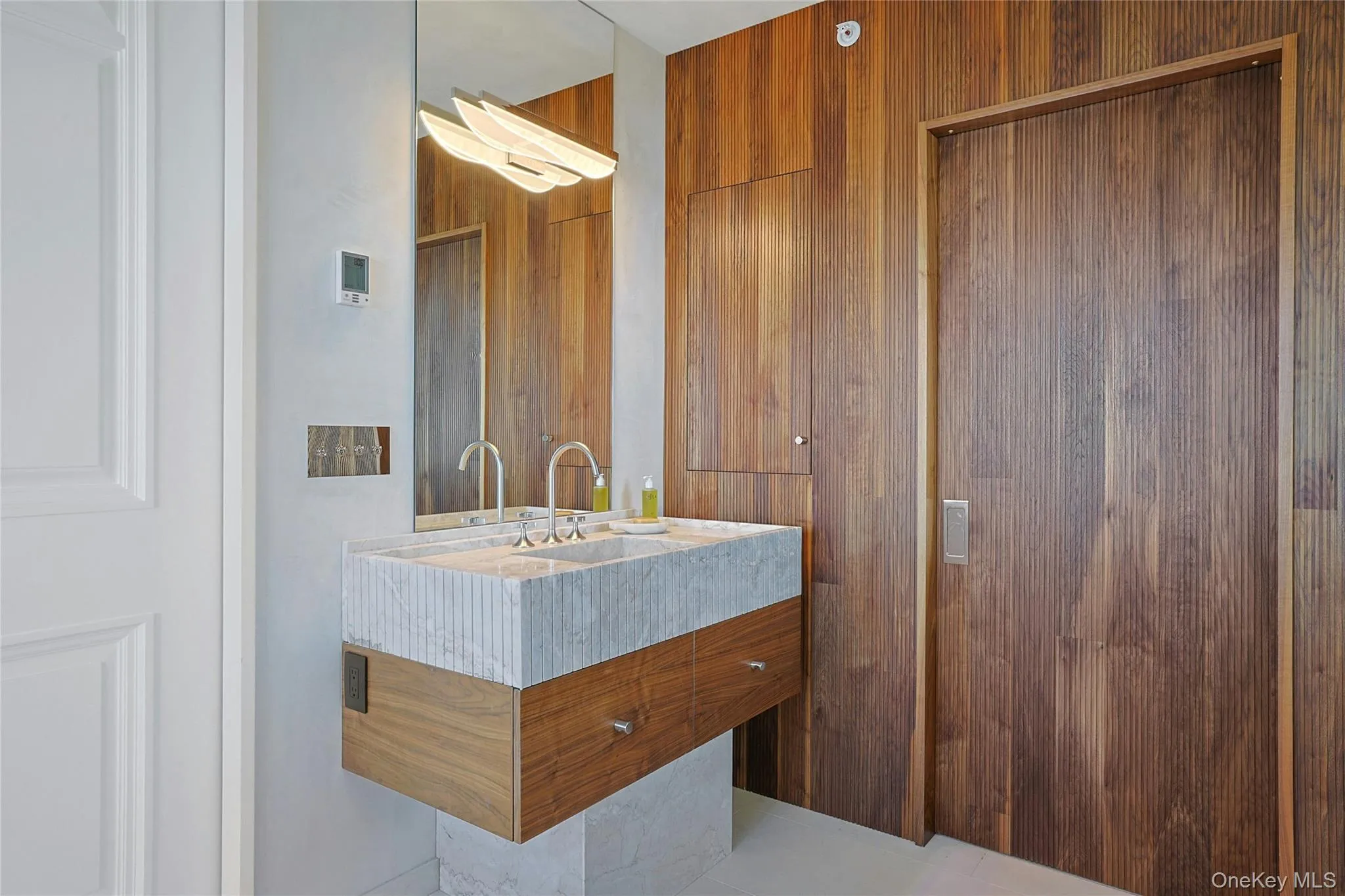 Bathroom featuring vanity and wood walls Bathroom featuring vanity and wood walls