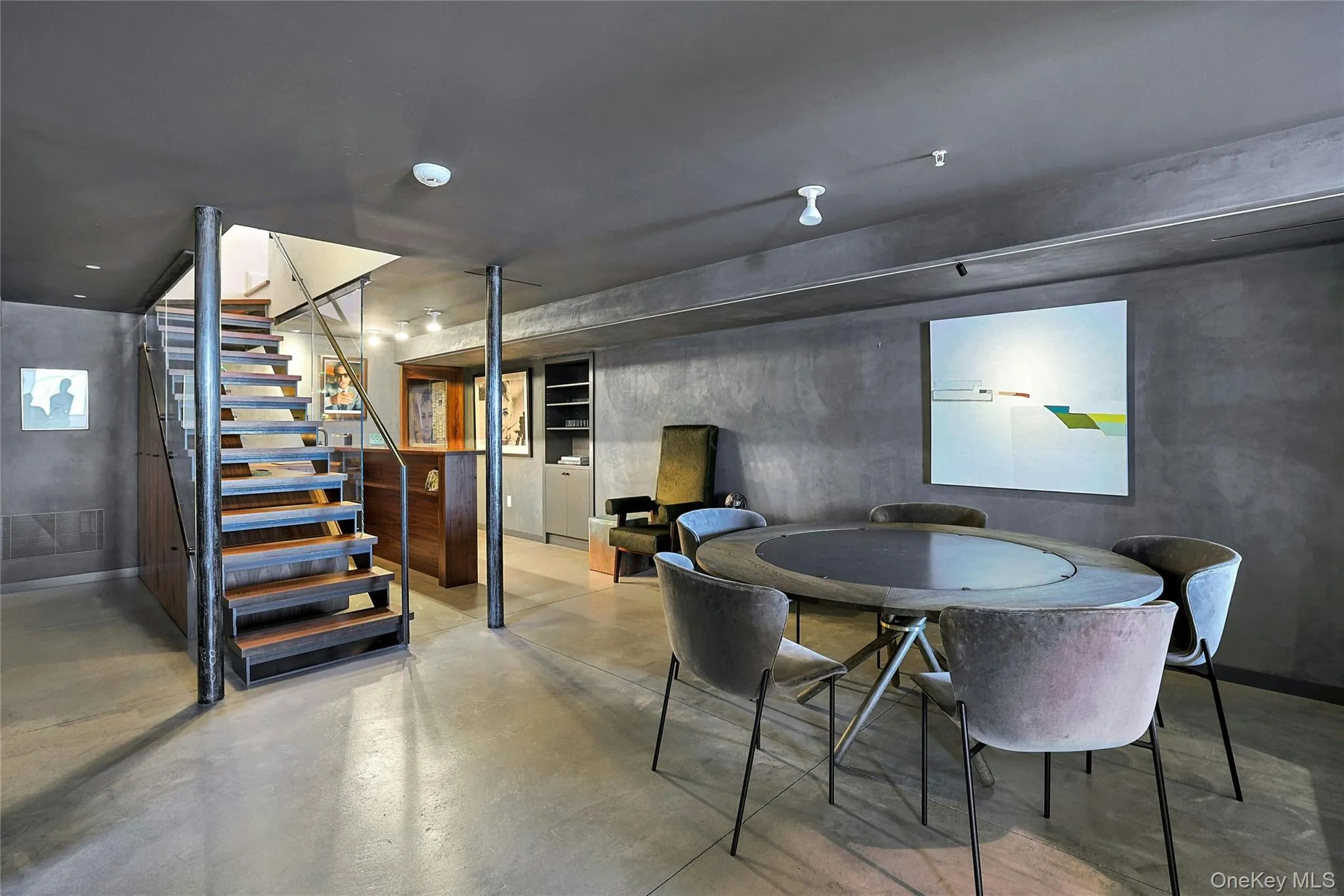 Dining space featuring stairs and finished concrete flooring Dining space featuring stairs and finished concrete flooring