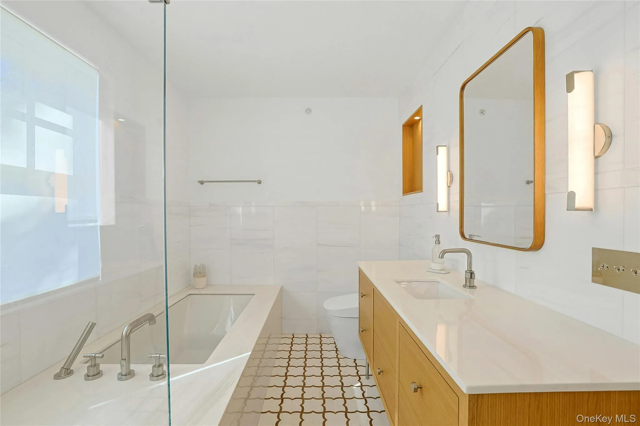 Full bathroom featuring tile walls, a bath, vanity, and light tile patterned flooring Full bathroom featuring tile walls, a bath, vanity, and light tile patterned flooring