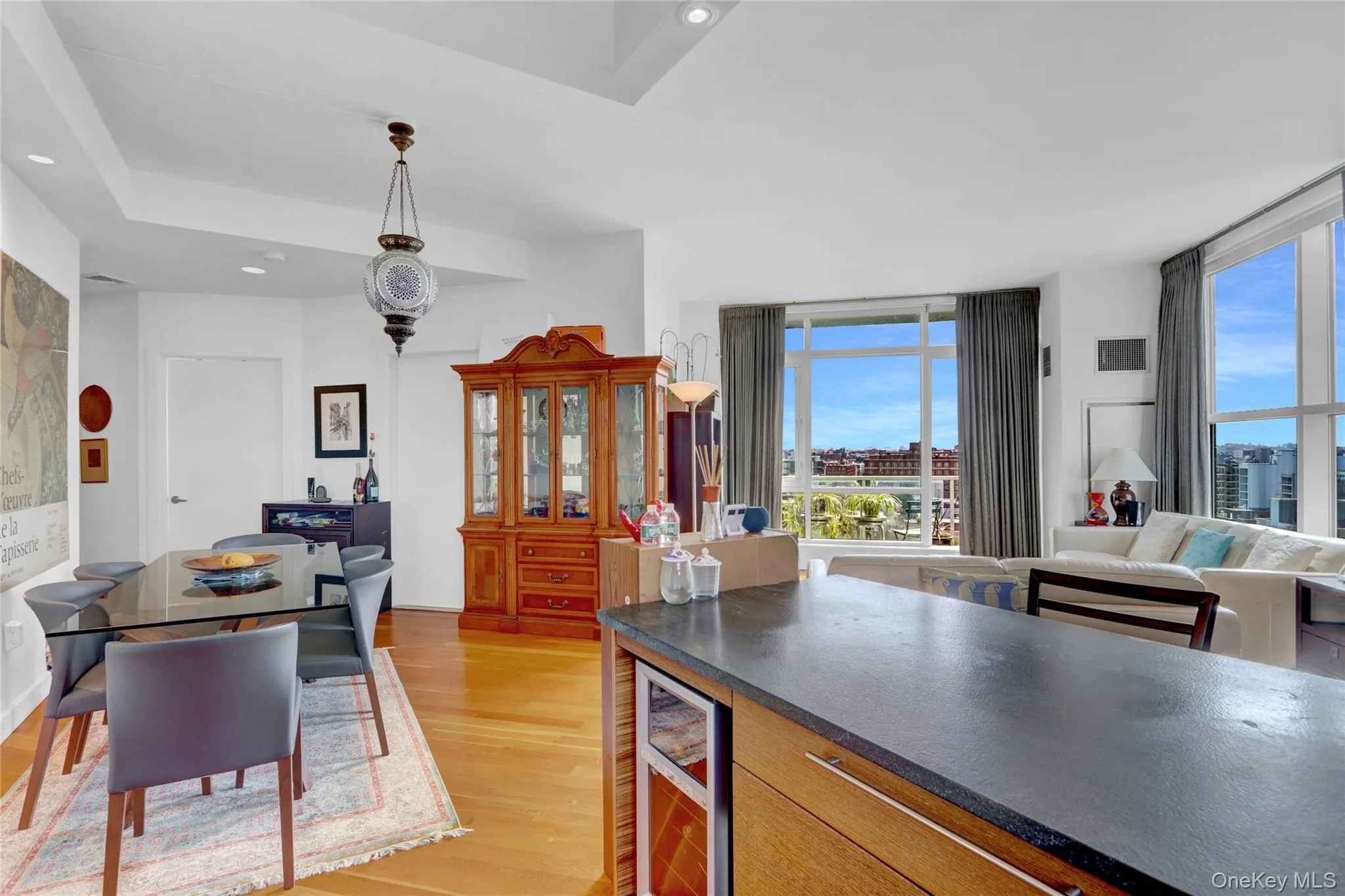 Kitchen featuring light wood-style flooring, open floor plan, wine cooler, dark stone counters, and recessed lighting Kitchen featuring light wood-style flooring, open floor plan, wine cooler, dark stone counters, and recessed lighting