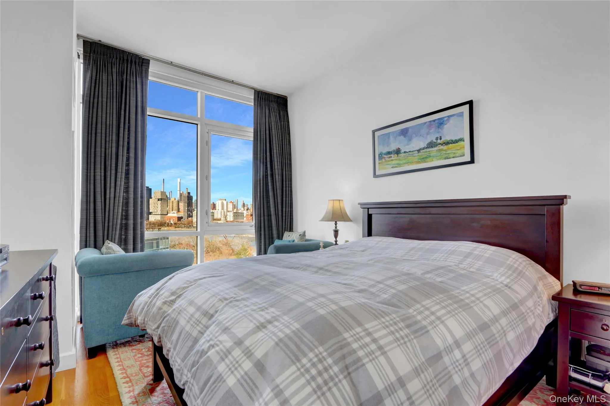 Bedroom featuring wood finished floors, a view of skyline, and expansive windows Bedroom featuring wood finished floors, a view of skyline, and expansive windows