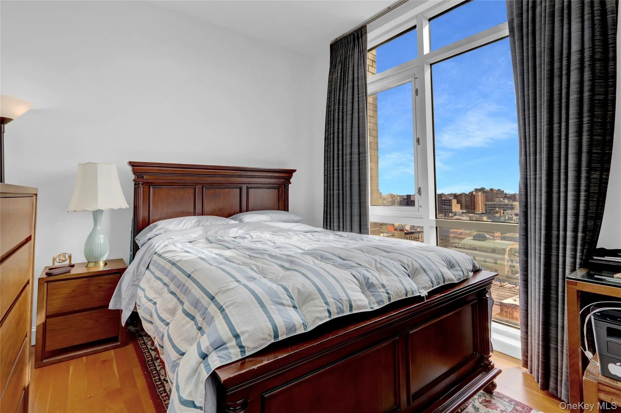 Bedroom with light wood finished floors and a city view Bedroom with light wood finished floors and a city view