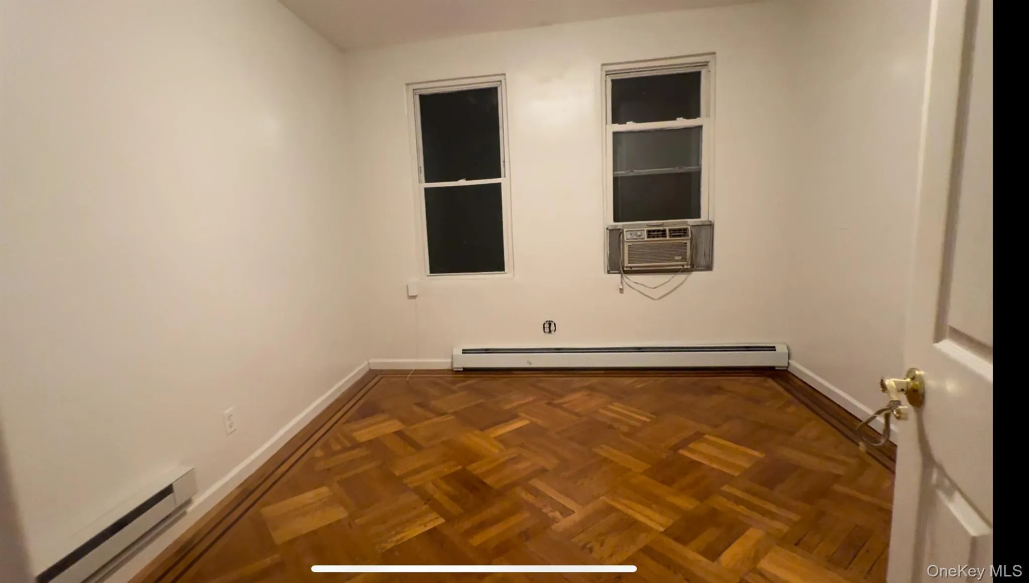 Empty room with a baseboard heating unit, a baseboard radiator, and cooling unit Empty room with a baseboard heating unit, a baseboard radiator, and cooling unit