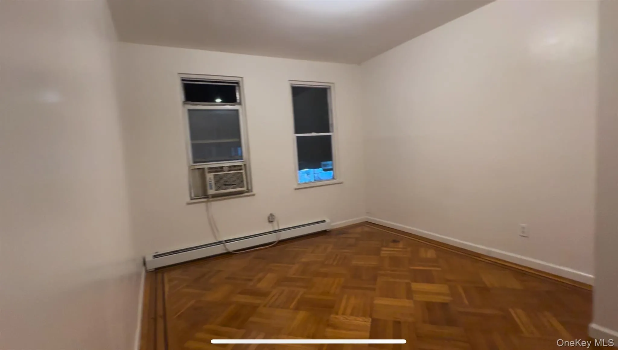 Empty room with baseboard heating and cooling unit Empty room with baseboard heating and cooling unit