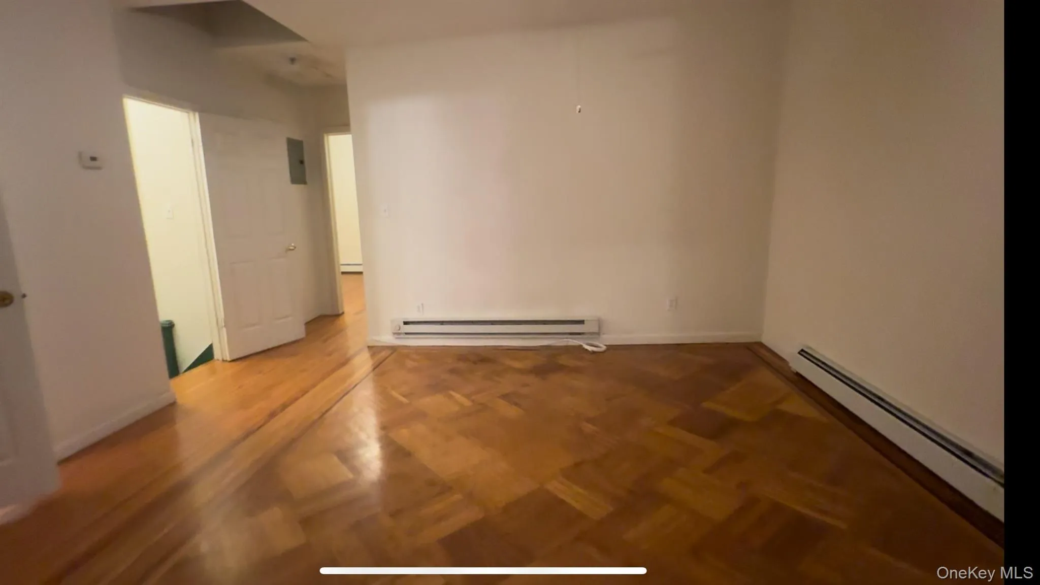 Empty room with baseboard heating and a baseboard radiator Empty room with baseboard heating and a baseboard radiator