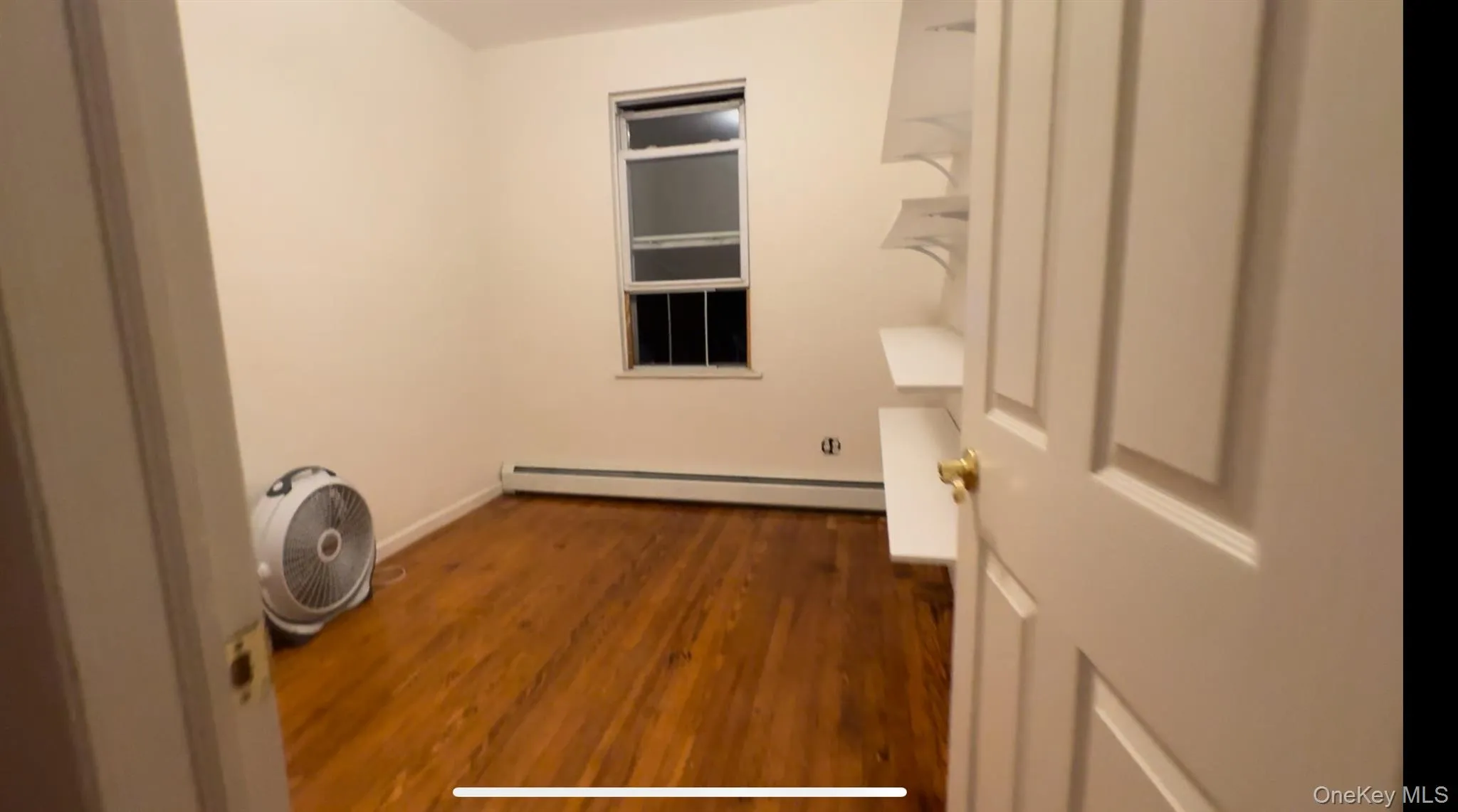Laundry area with dark wood-type flooring and baseboard heating Laundry area with dark wood-type flooring and baseboard heating